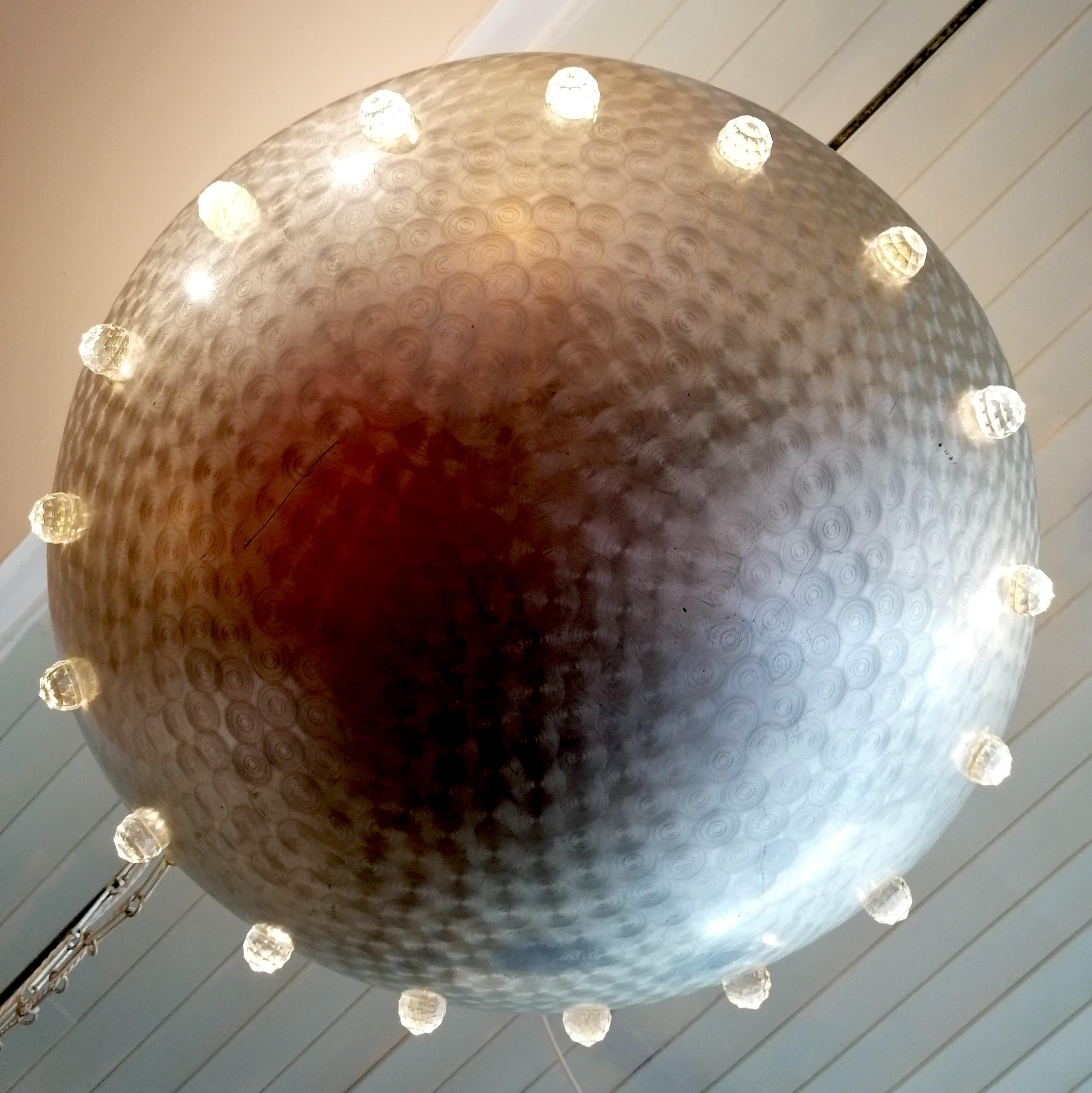 Amazing large postmodern American ceiling light: cast aluminium dome studded with crystal balls, through which the light shines. It hangs on rectangular chain suspended from an aluminum ball.
The only one I can find online is attributed to Rupert
