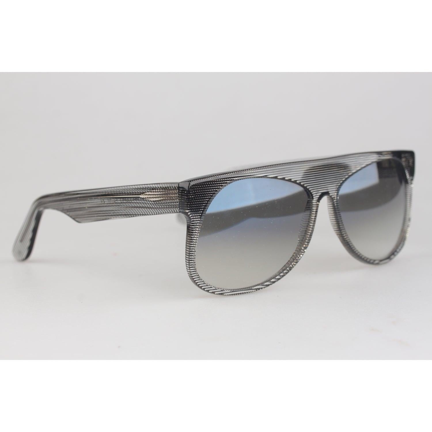 Abbraccia l'eleganza dell'artigianato italiano senza tempo con questi splendidi occhiali da sole L.G.R., caratterizzati da un bellissimo motivo a nido con strisce nere a zig-zag intrecciate in una montatura in acetato trasparente. Il design