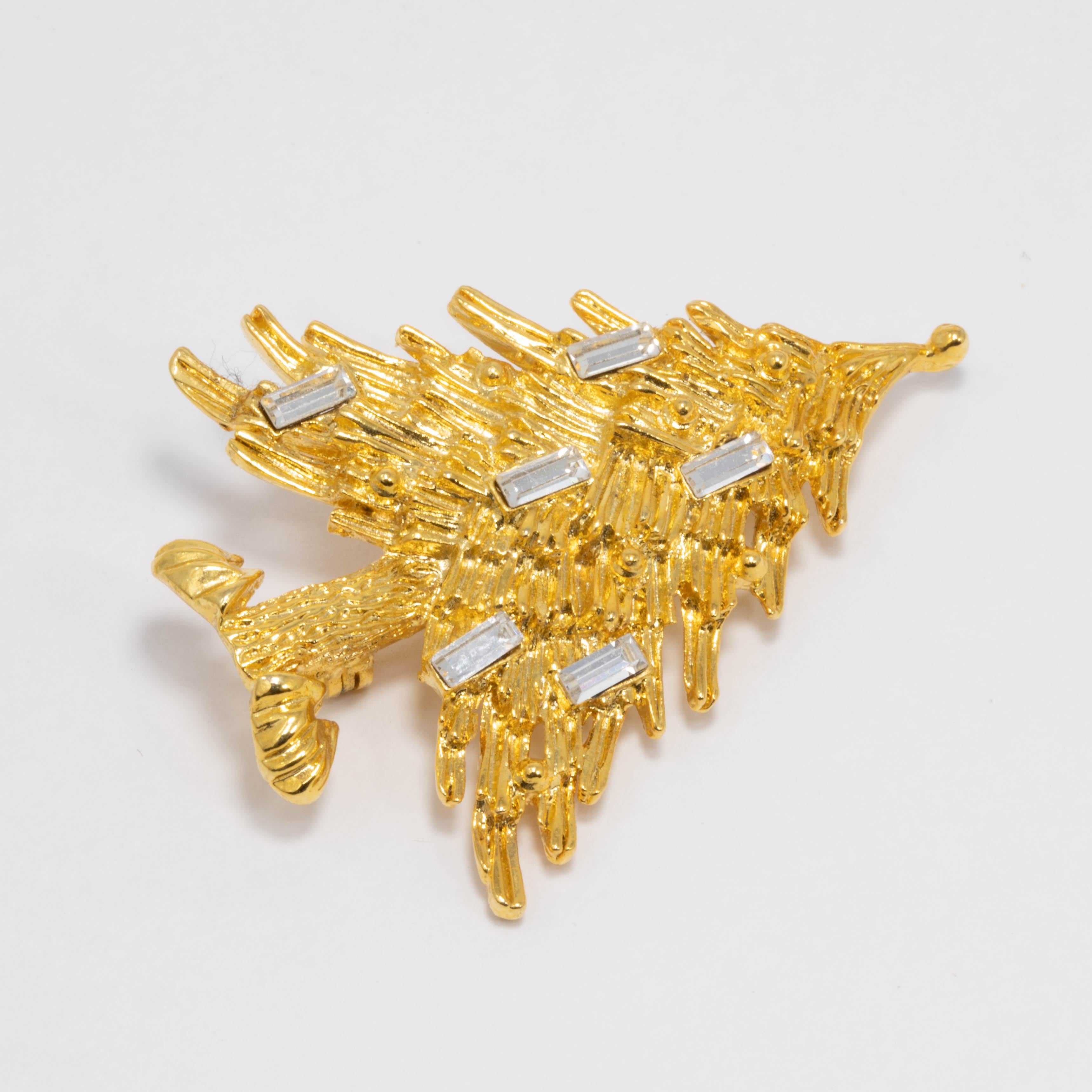 Festive Christmas tree pin brooch, featuring a textured golden evergreen fir tree decorated with baguette-cut clear crystals.

Gold plated.

Tags, Marks, Hallmarks: © LIA, Made in USA