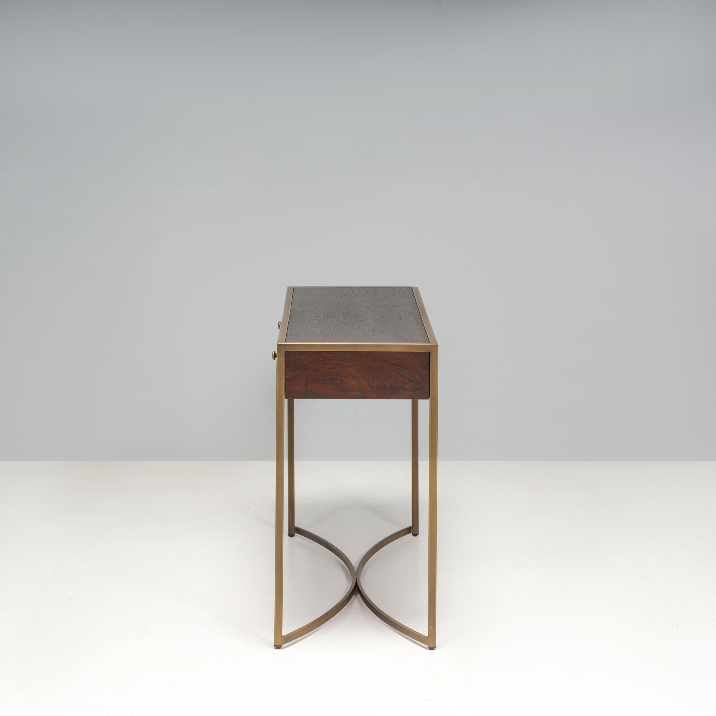 Das 2011 gegründete Unternehmen Liang & Eimil entwirft zeitlose Möbel, bei denen hochwertige Materialien und Nachhaltigkeit im Vordergrund stehen. Die Rivoli-Dekoration besteht aus einem braunen Eschenfurnier mit messingfarbenen Metallverzierungen,
