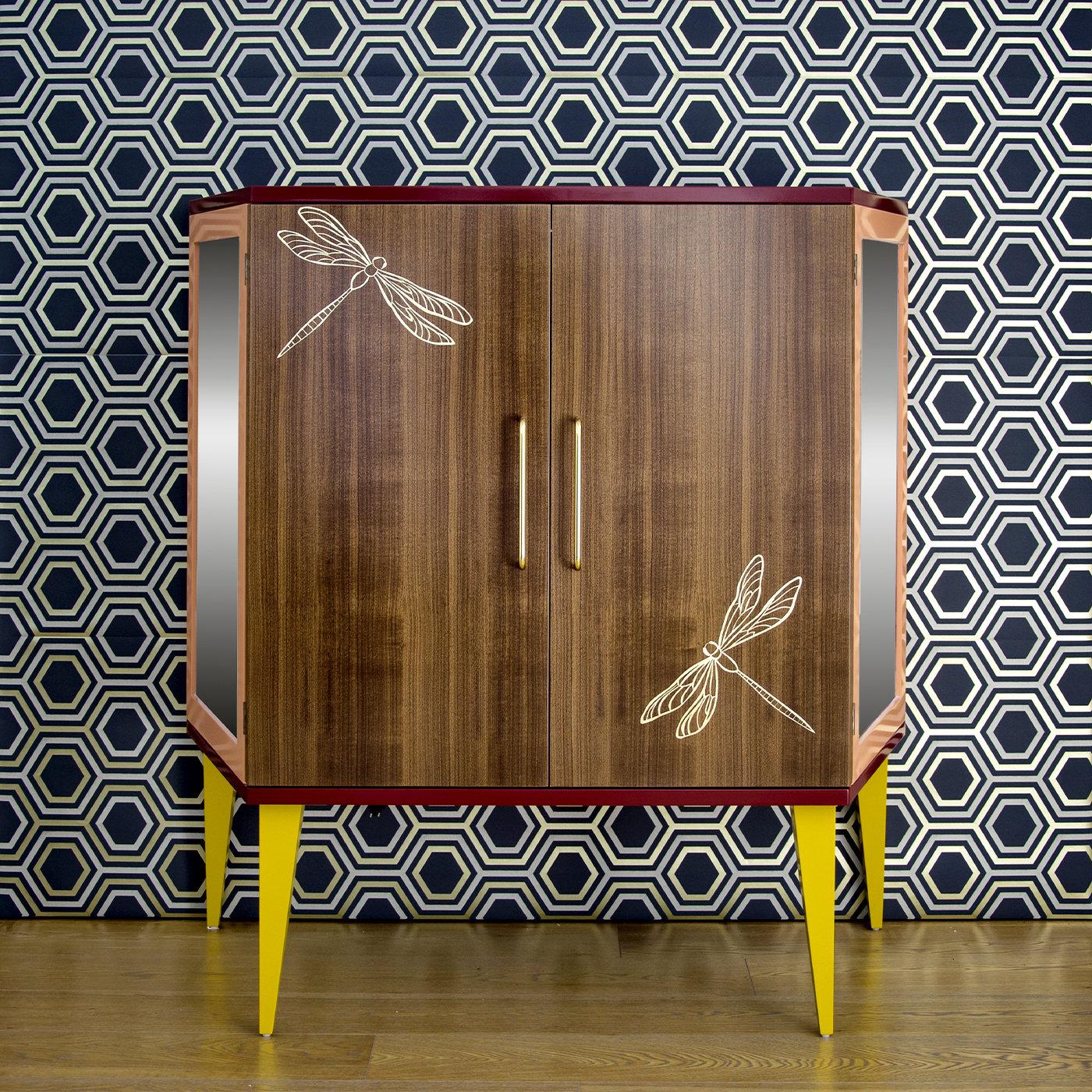 This walnut wood shoe cabinet features two doors decorated with two large, white dragonflies and brass handles. The sides are made of glass and Vienna straw to guarantee breathability and show that practicality can also mean beauty. Inside are