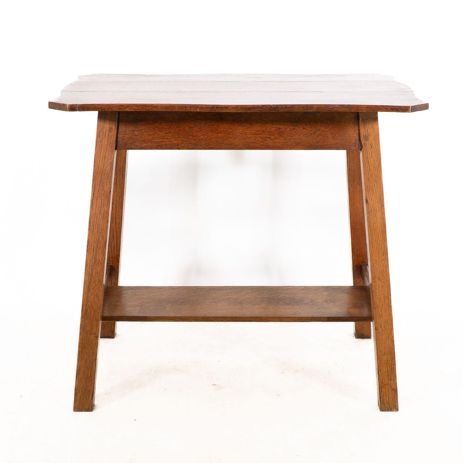 Liberty and Co. Table de chevet oblongue en chêne de style Arts & Crafts, avec un plateau en forme et une étagère inférieure sur des pieds carrés évasés.