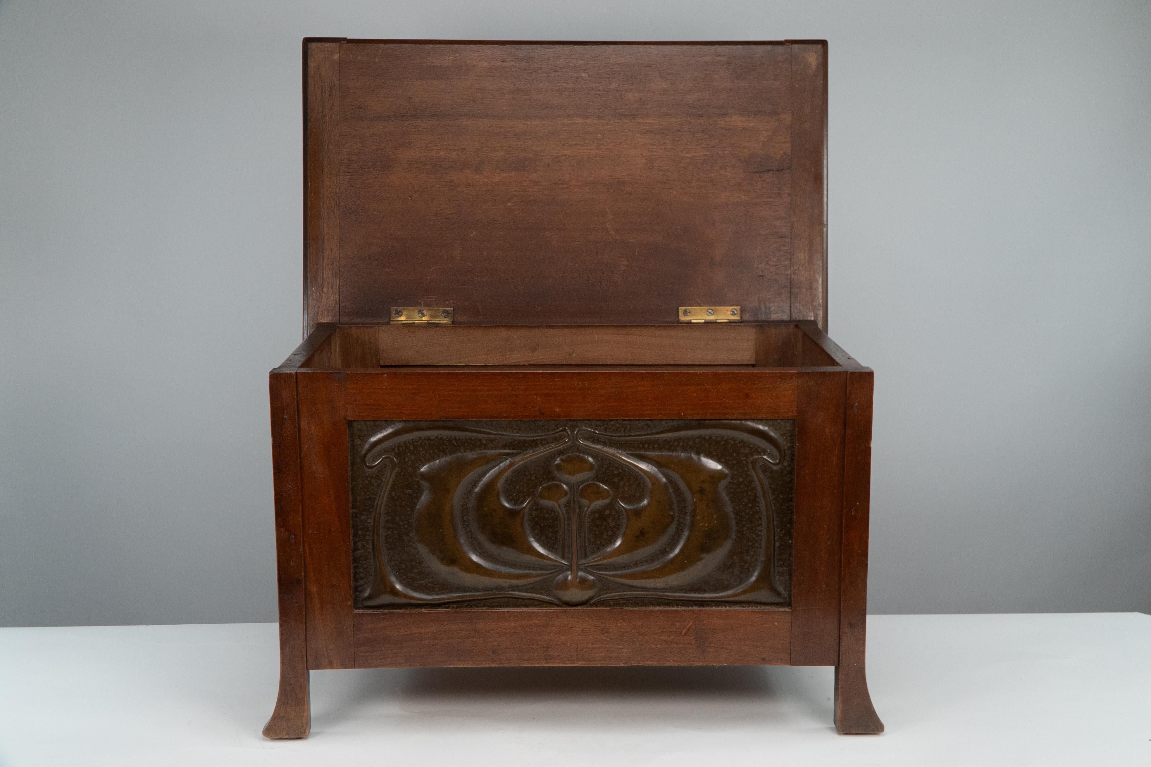 Liberty & Co, in the Glasgow Style. A small trunk or toybox with floral copper panels to the front and sides that are in the style of C R Mackintosh.