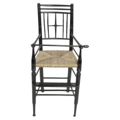 Liberty & Co. An Argyle Aesthetic Movement ebonized rush seat child's high chair