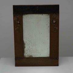 Liberty and Co. An Arts and Crafts copper mirror with floral details