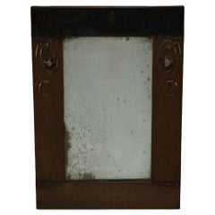 Liberty and Co. An Arts and Crafts copper mirror with floral details