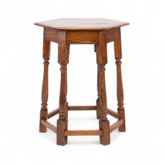 Liberty and Co. An Arts and Crafts oak side table with a hexagonal top