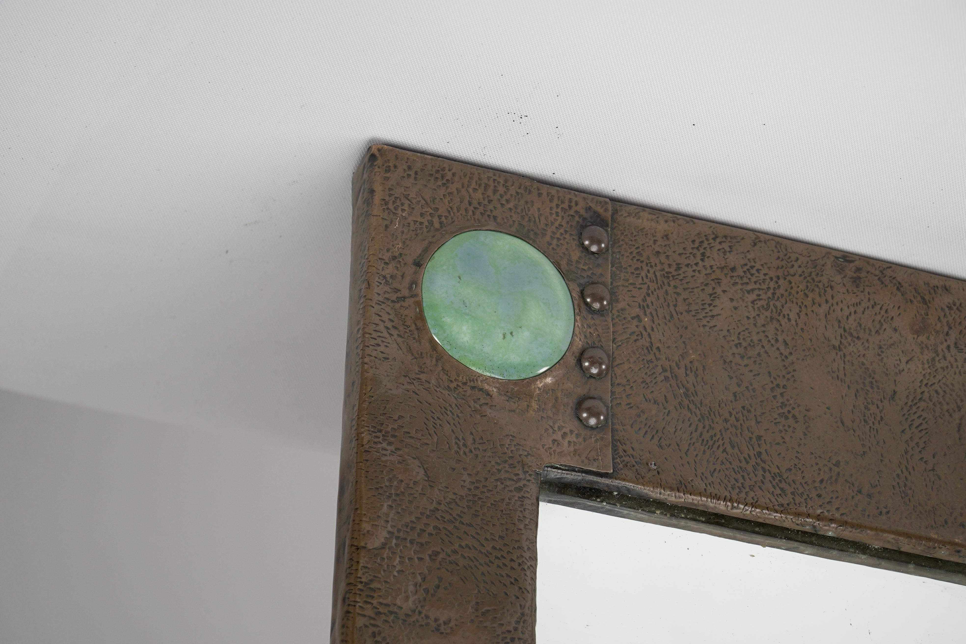 Arts and Crafts Liberty and Co. An Arts & Crafts copper mirror with a cloudy blue Ruskin Jewel For Sale