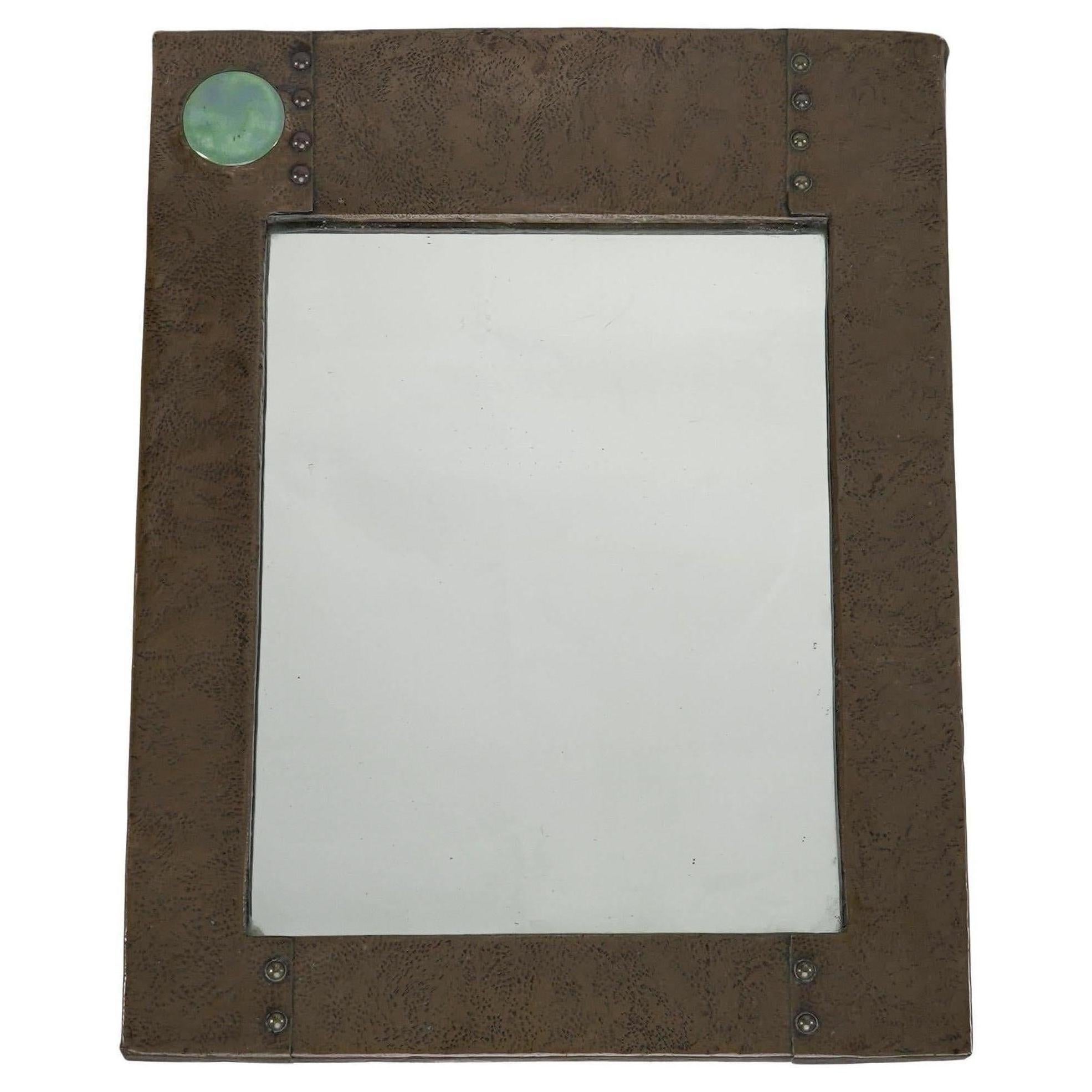 Liberty and Co. An Arts & Crafts copper mirror with a cloudy blue Ruskin Jewel