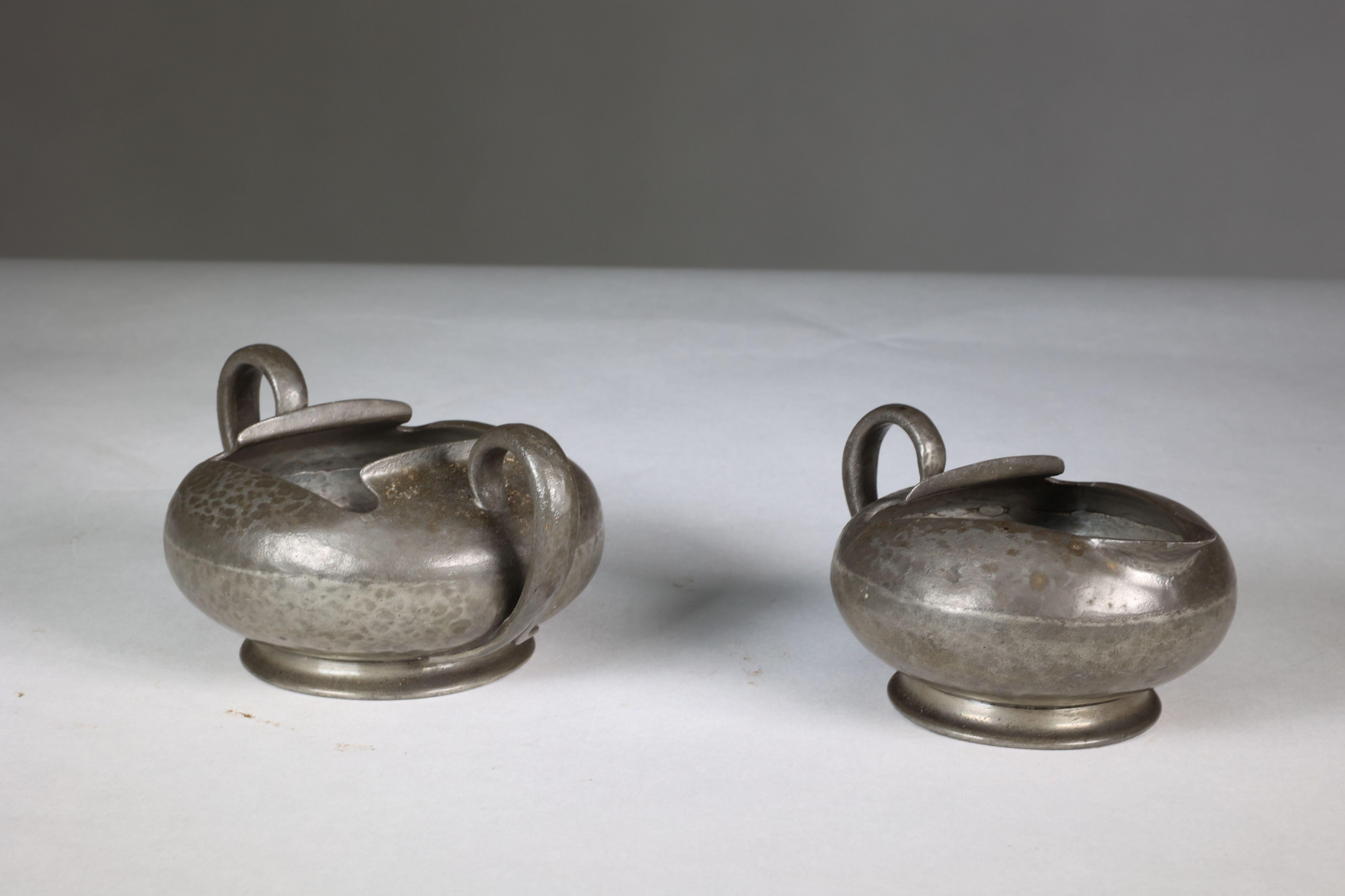 Liberty and Co. Stamped Made in England. English Pewter 0966. An Arts and Crafts milk and sugar bowl. Circa 1905. Price for the pair.