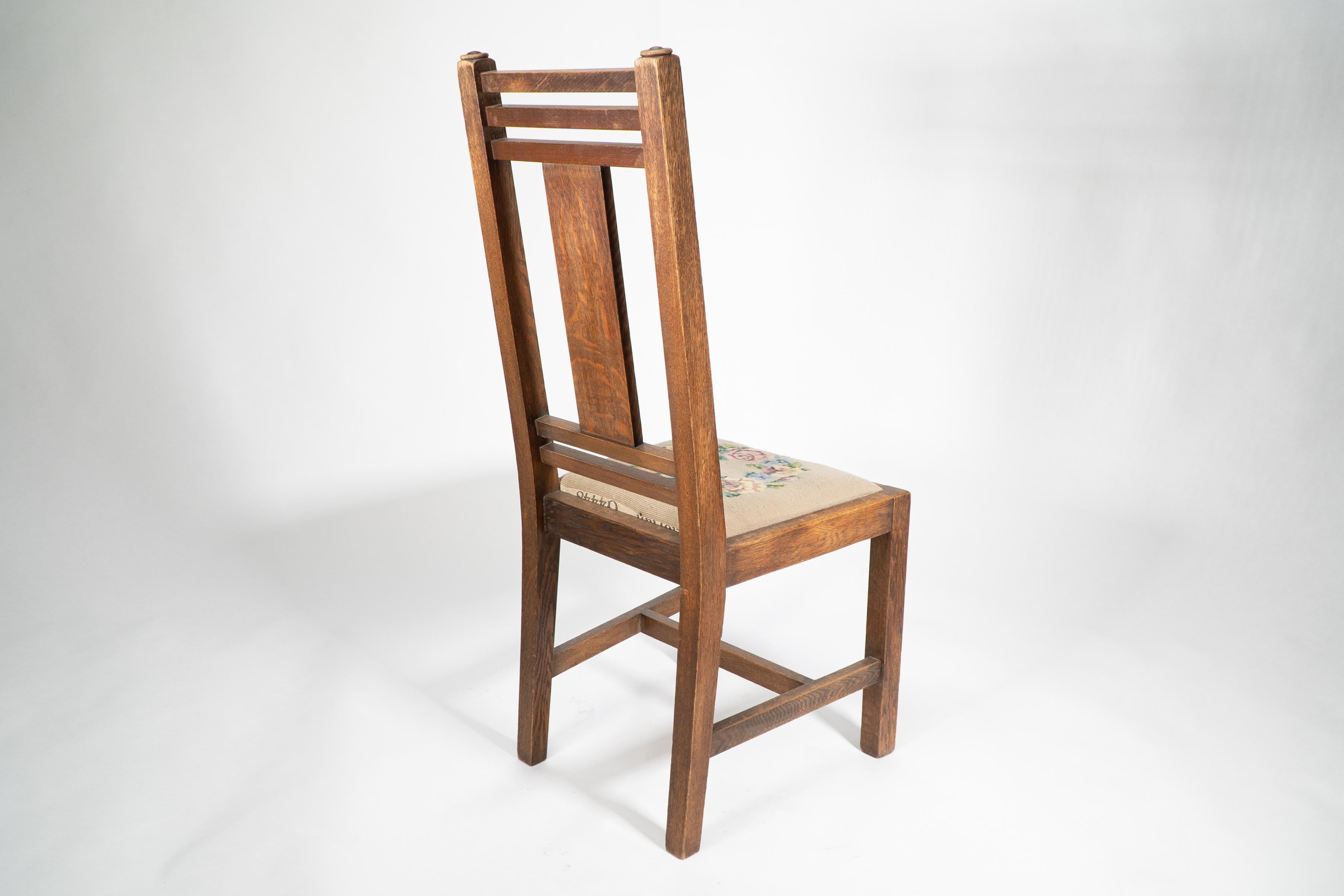 Liberty & Co. An Arts & Crafts oak chair with carved rose decoration to the back In Good Condition For Sale In London, GB