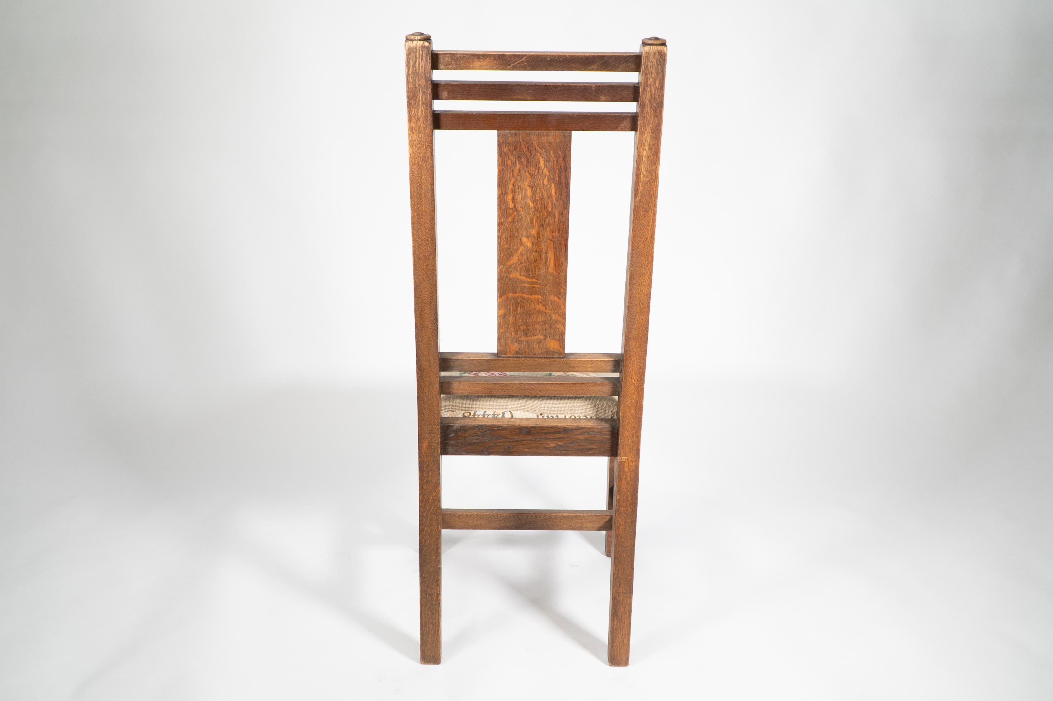 Oak Liberty & Co. An Arts & Crafts oak chair with carved rose decoration to the back For Sale