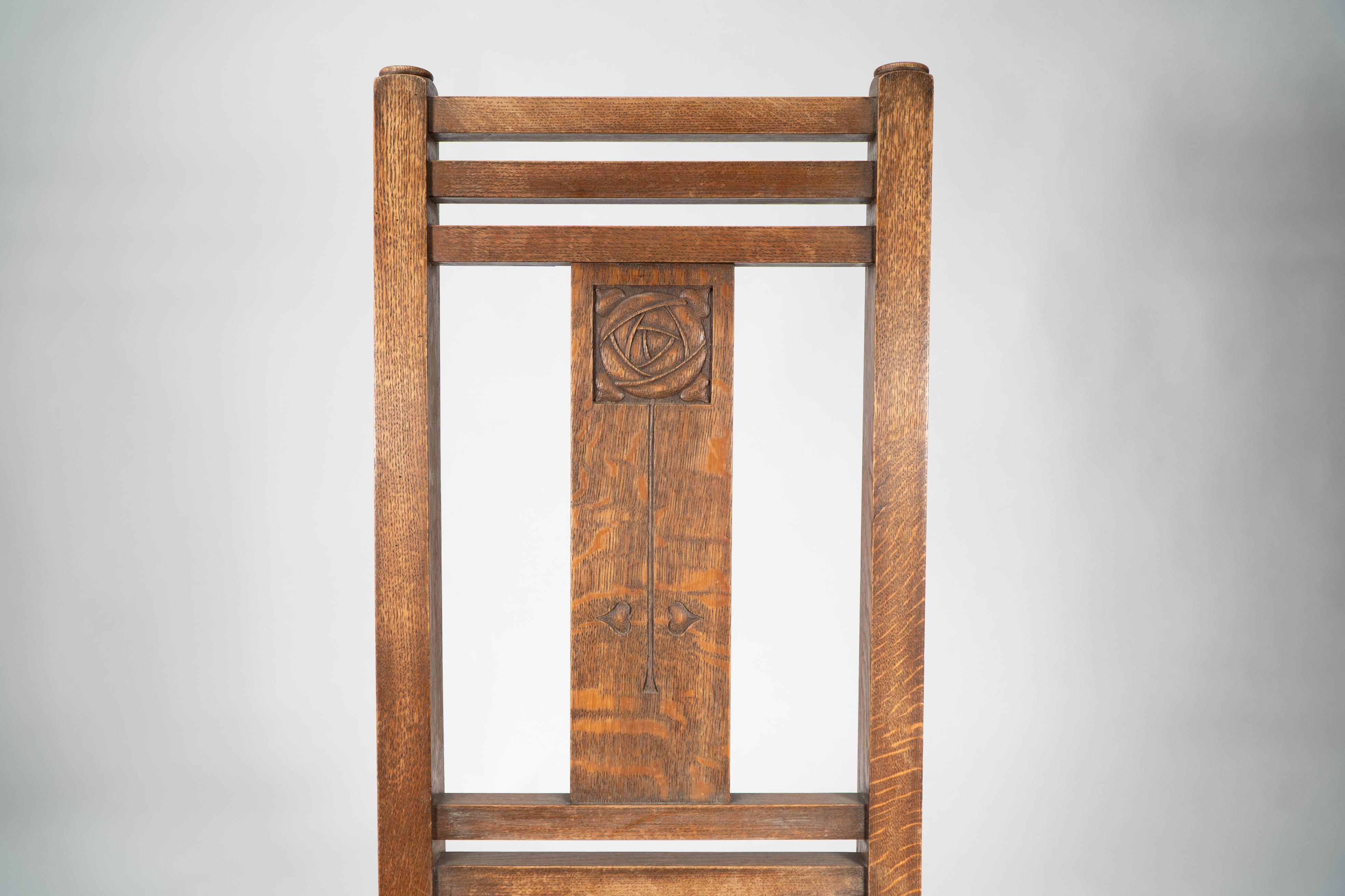 Liberty & Co. An Arts & Crafts oak chair with carved rose decoration to the back For Sale 1