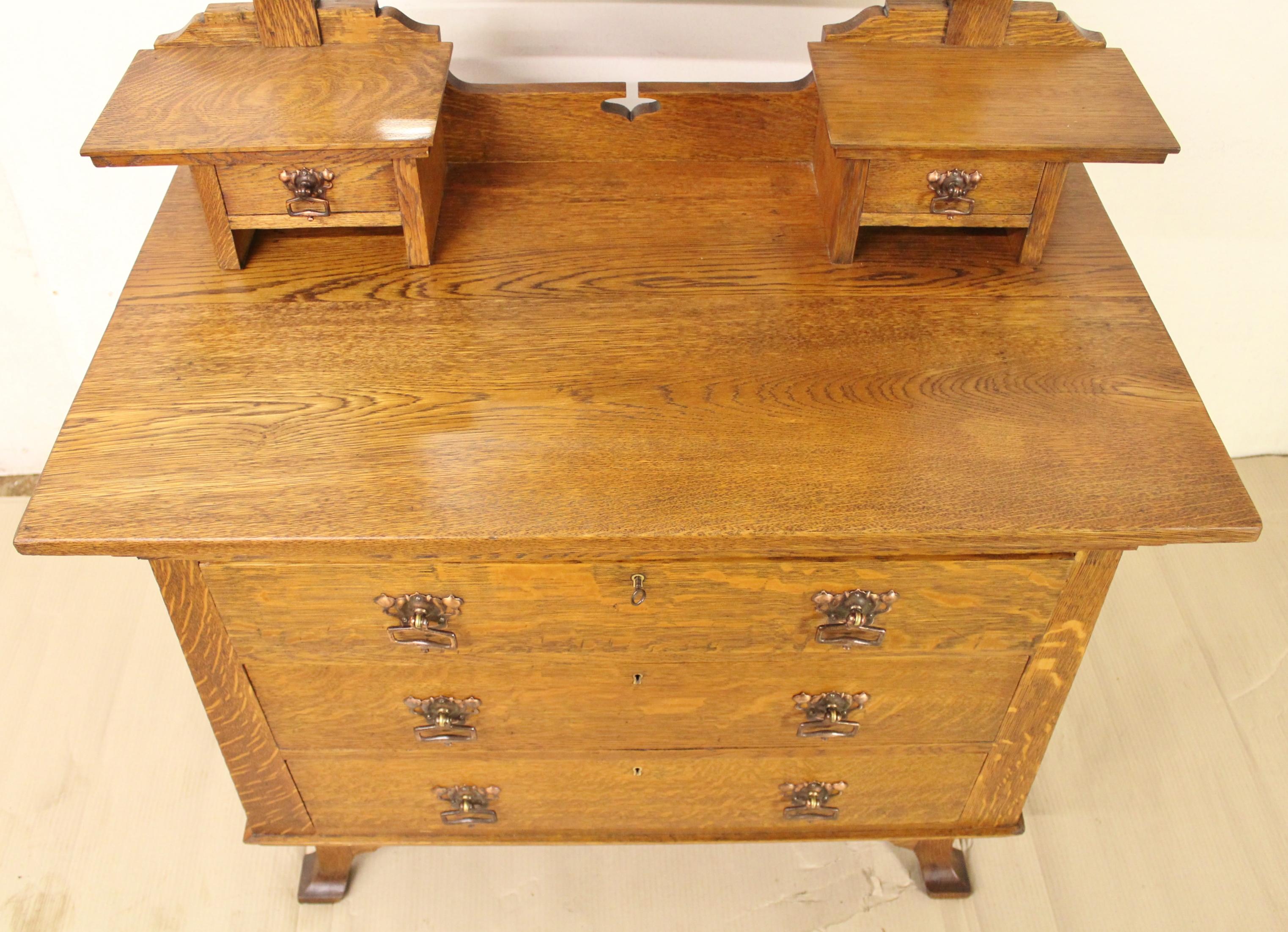 A fantastic and rare oak arts and crafts or art nouveau dressing chest as originally retailed by Liberty and Co. Of superb construction in solid English oak, now with a wonderful honey tone and patina. With beautiful design features redolent of the
