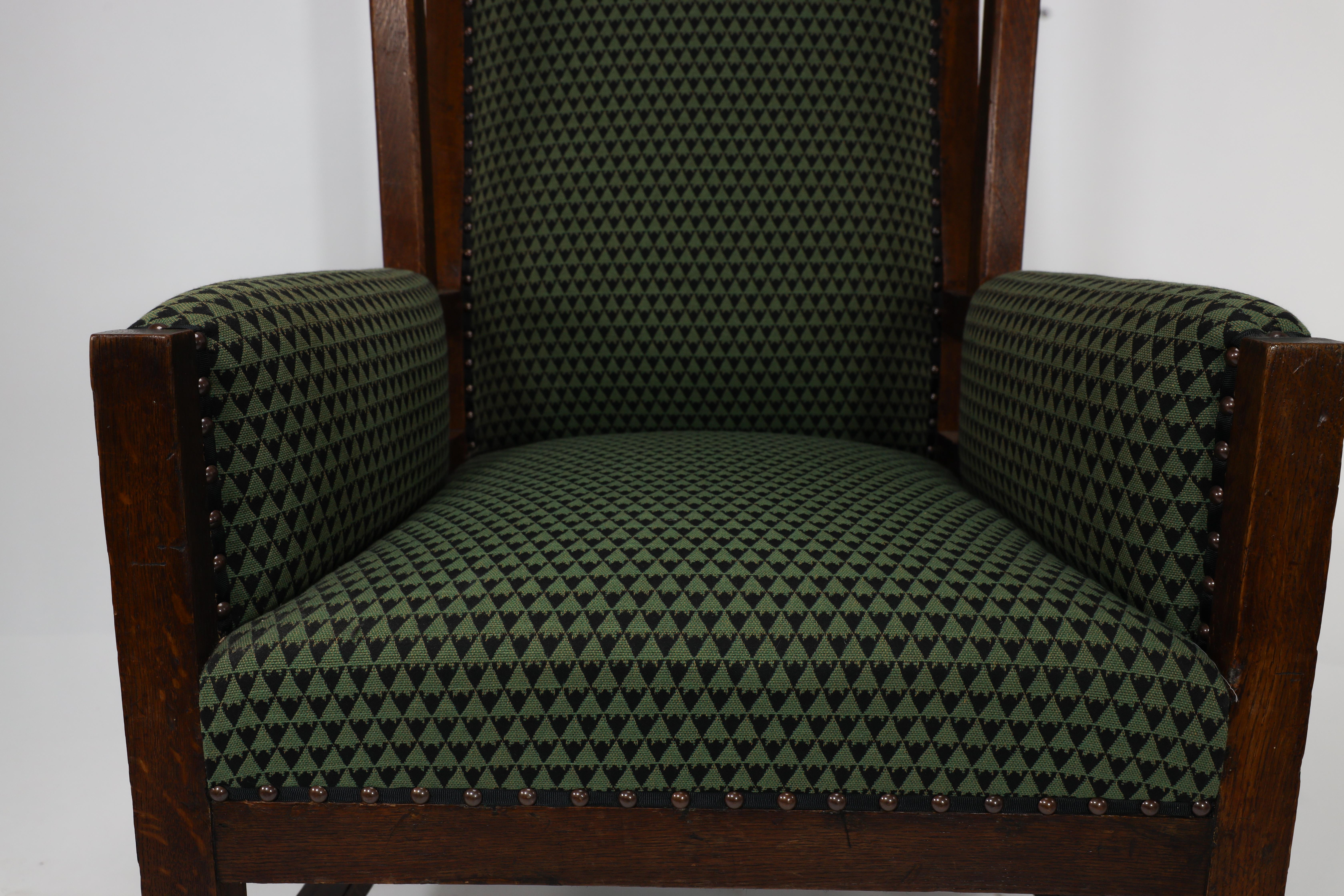 Liberty and Co, attr. in the style of Leonard Wyburd. An oak wing back armchair For Sale 5