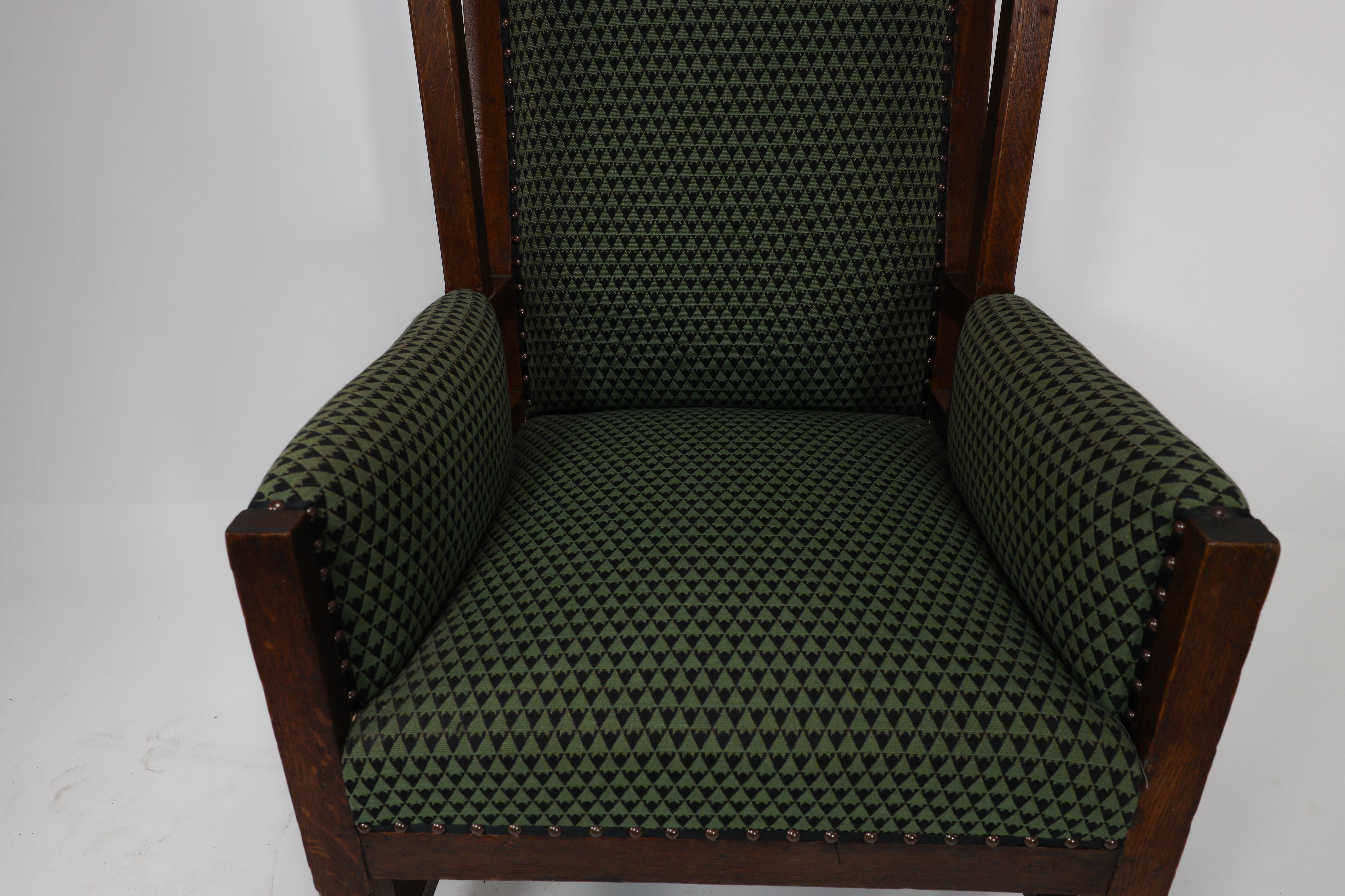 Liberty and Co, attr. in the style of Leonard Wyburd. An oak wing back armchair For Sale 6