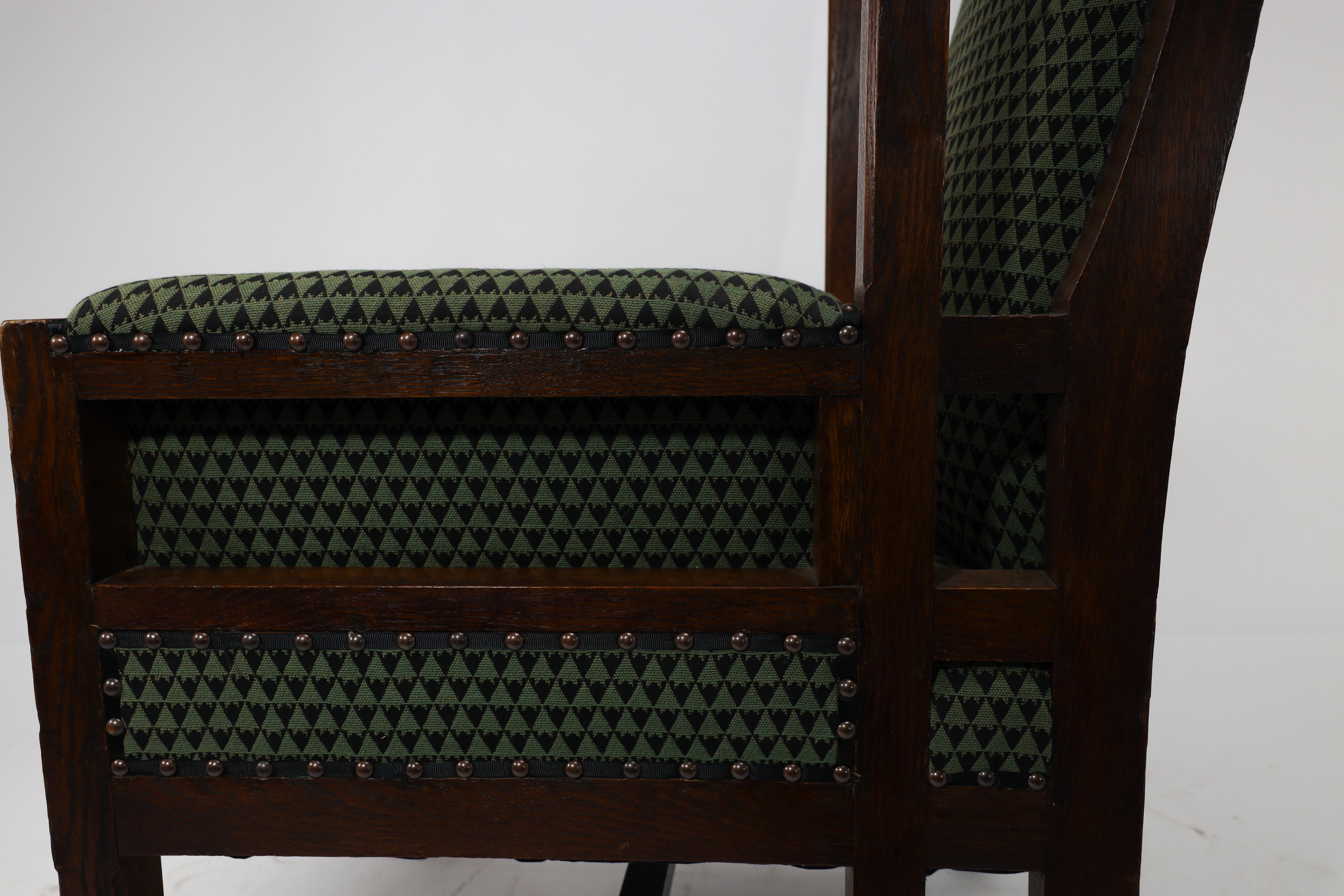 Liberty and Co, attr. in the style of Leonard Wyburd. An oak wing back armchair For Sale 10