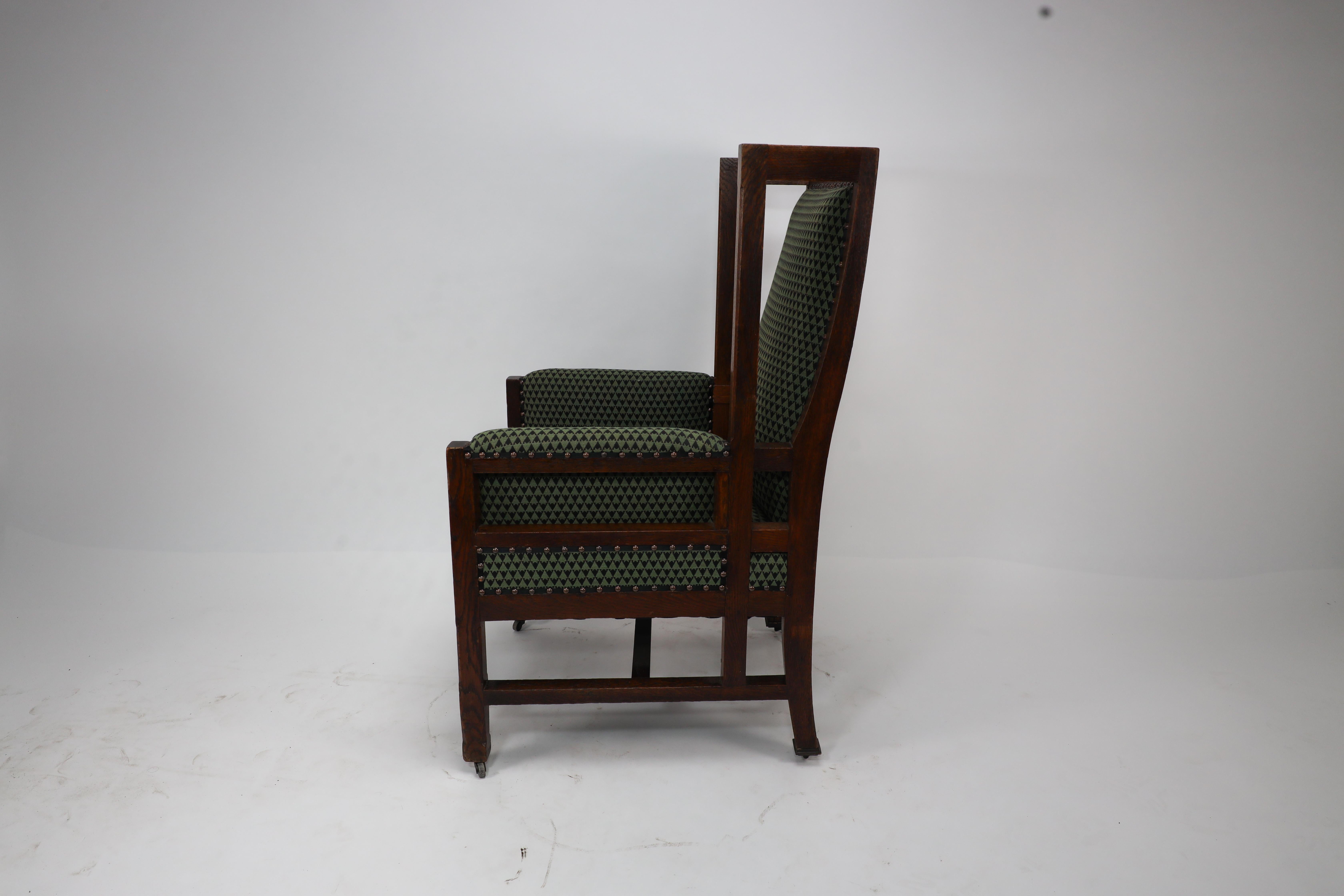 English Liberty and Co, attr. in the style of Leonard Wyburd. An oak wing back armchair For Sale