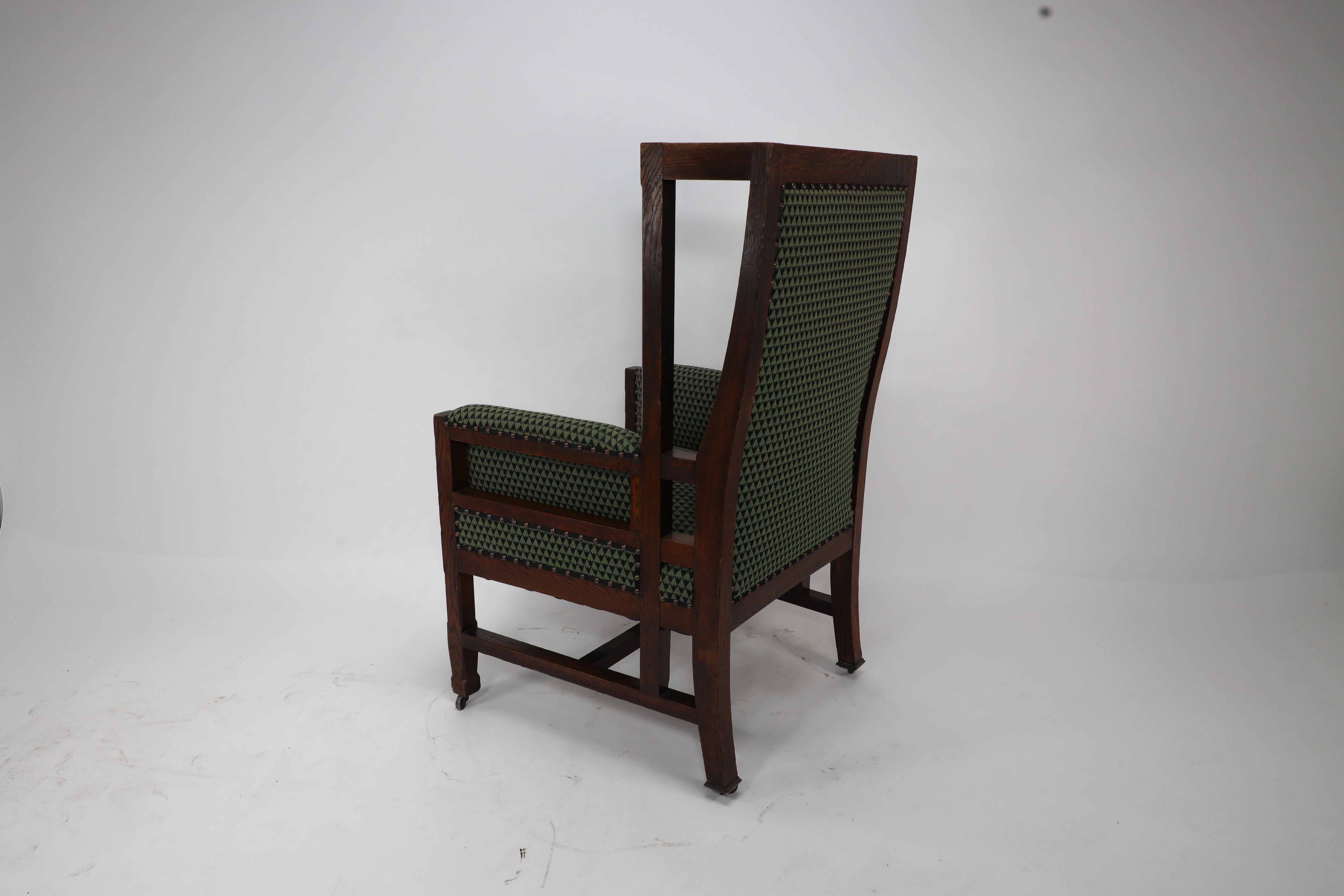 Liberty and Co, attr. in the style of Leonard Wyburd. An oak wing back armchair In Good Condition For Sale In London, GB