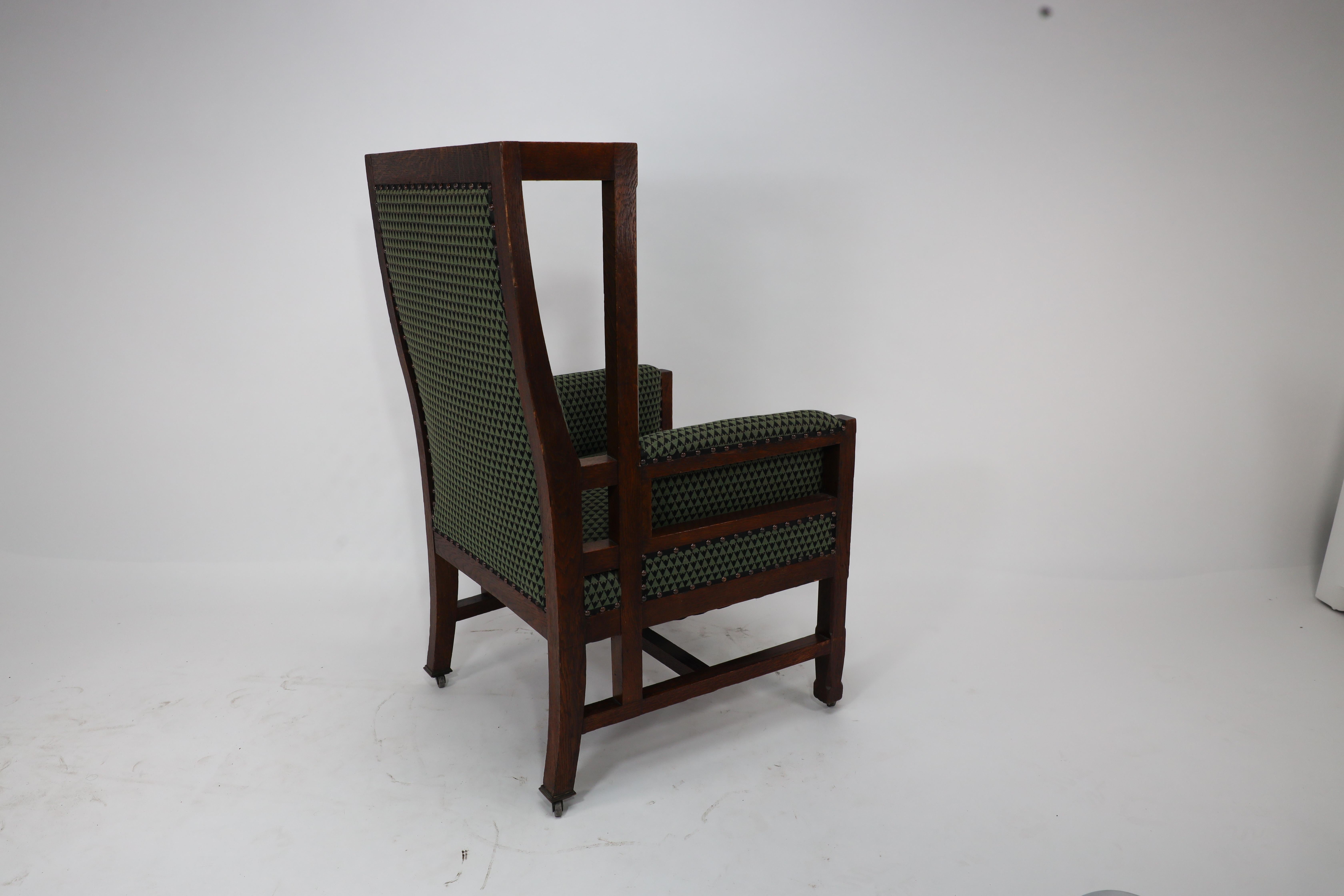 Late 19th Century Liberty and Co, attr. in the style of Leonard Wyburd. An oak wing back armchair For Sale