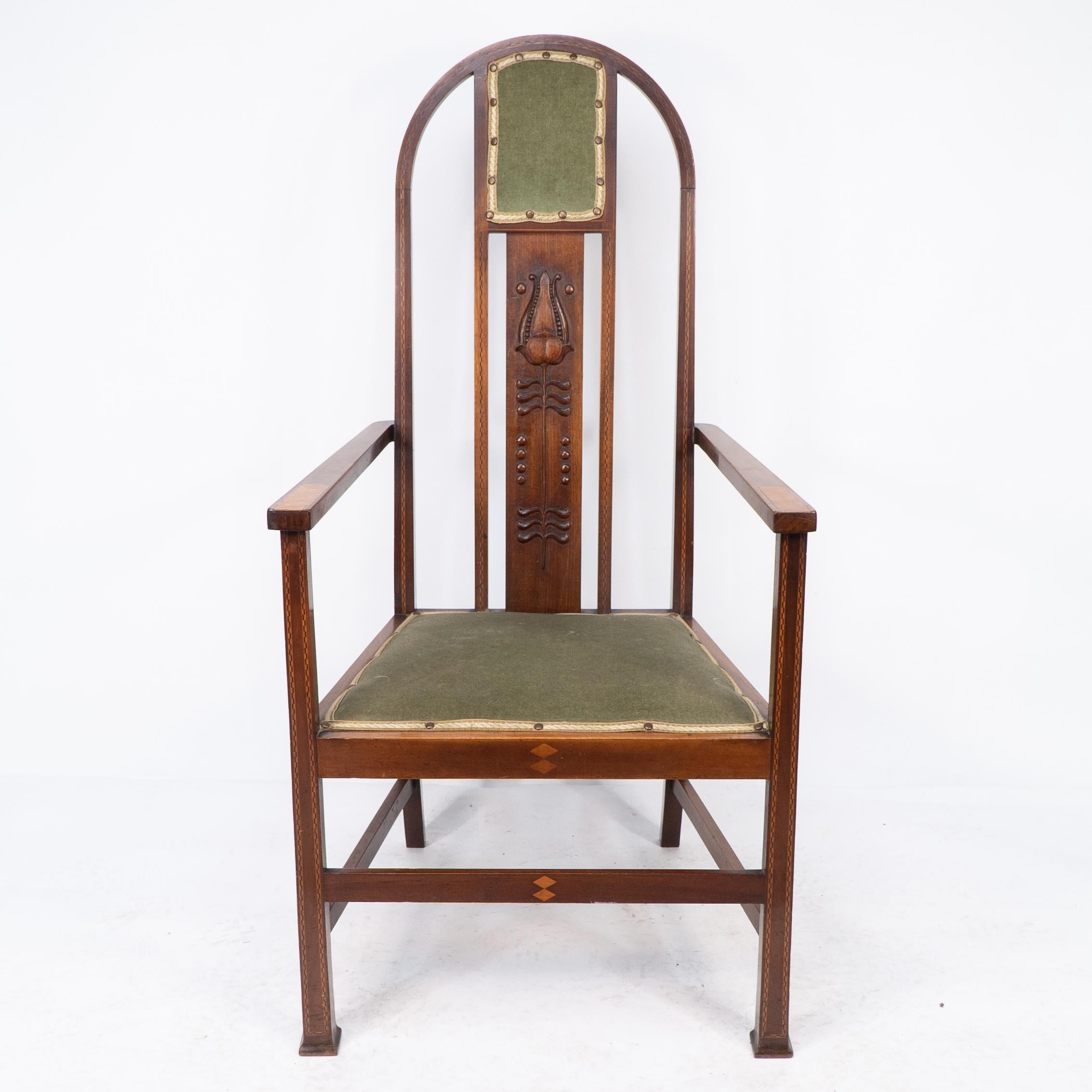 Liberty and Co attri, A pair of Arts and Crafts mahogany armchair, with carved stylized plant motif to the central splat fland by chequered ebony and boxwood stringing and inlaid Walnut strips to the arms with double diamond inlay to the front seat