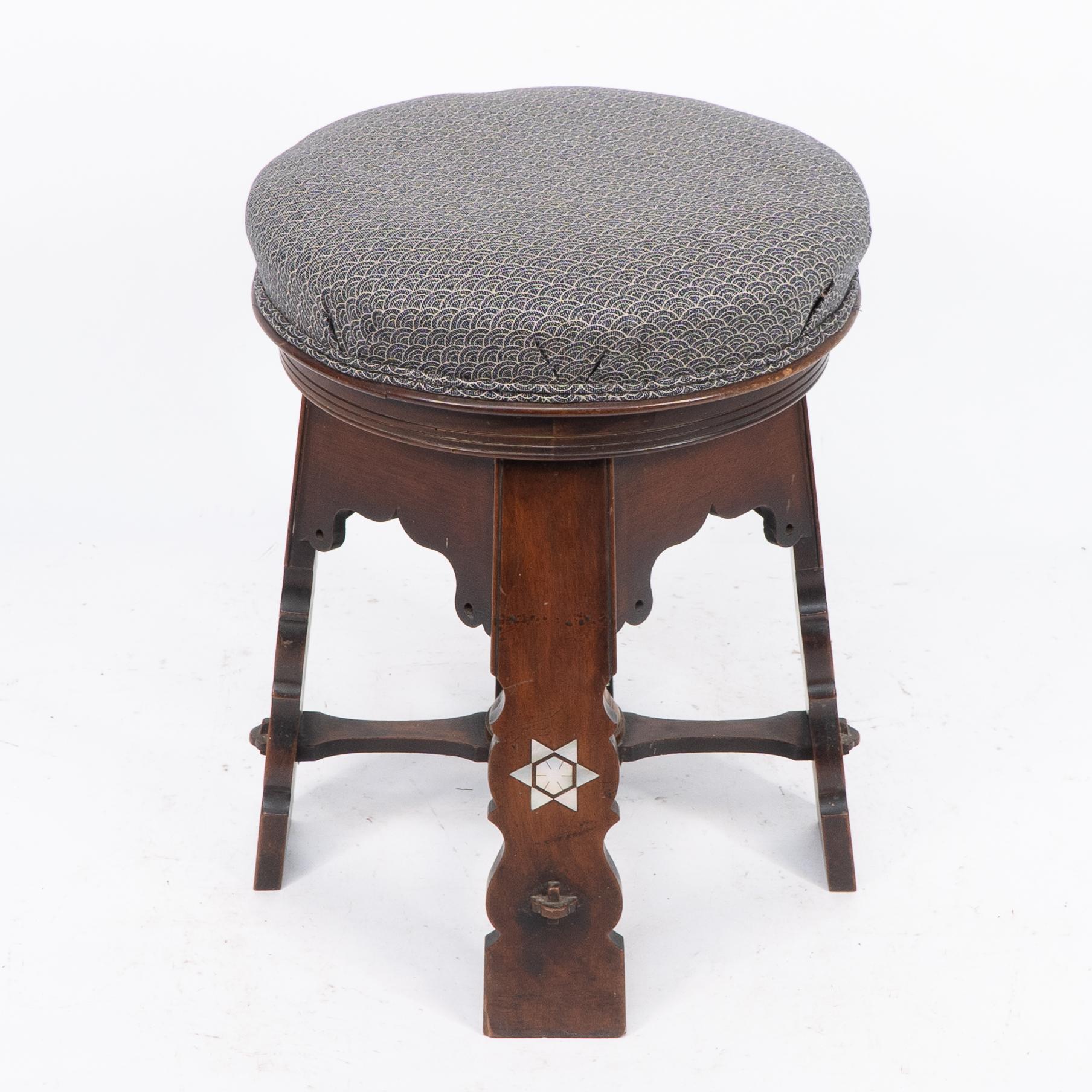 Liberty and Co (zugeschrieben). Ein seltener Drehhocker aus maurischem Nussbaum mit maurischen Bögen und Perlmutt-Sternintarsien auf den Füßen. Wir haben den Sitz professionell mit einem hochwertigen blauen Stoff aufpolstern lassen.
