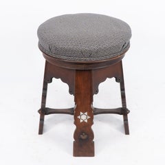 Liberty and Co attri. A rare Moorish walnut revolving stool with Moorish arches