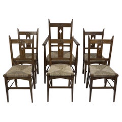 Antique Liberty & Co attributed. Set of six Glasgow Style oak & rush seat dining chairs.