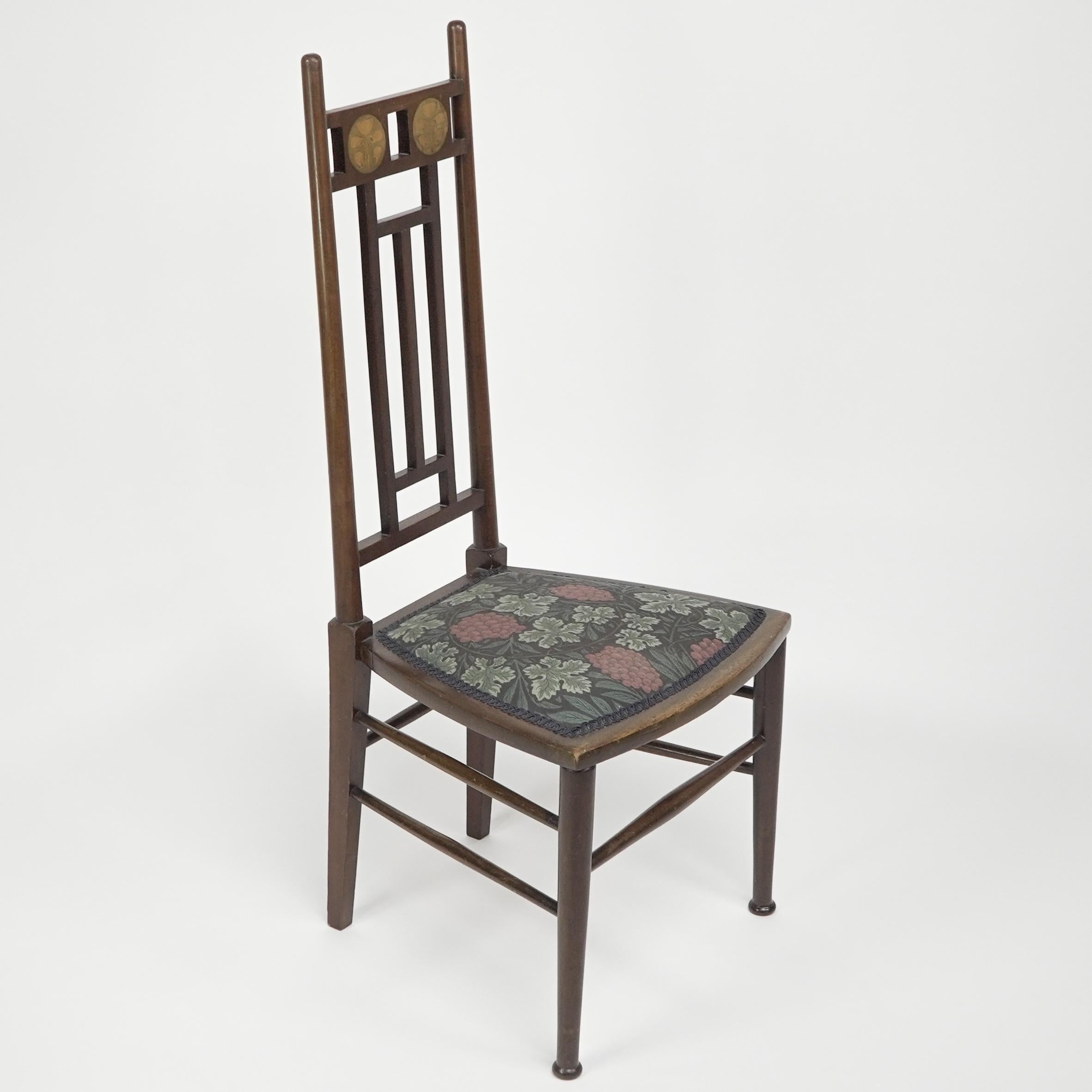E G Punnett pour Liberty & Co, réalisé par William Birch. Chaise d'appoint en noyer avec incrustations florales circulaires en sycomore et en buis au dos.
