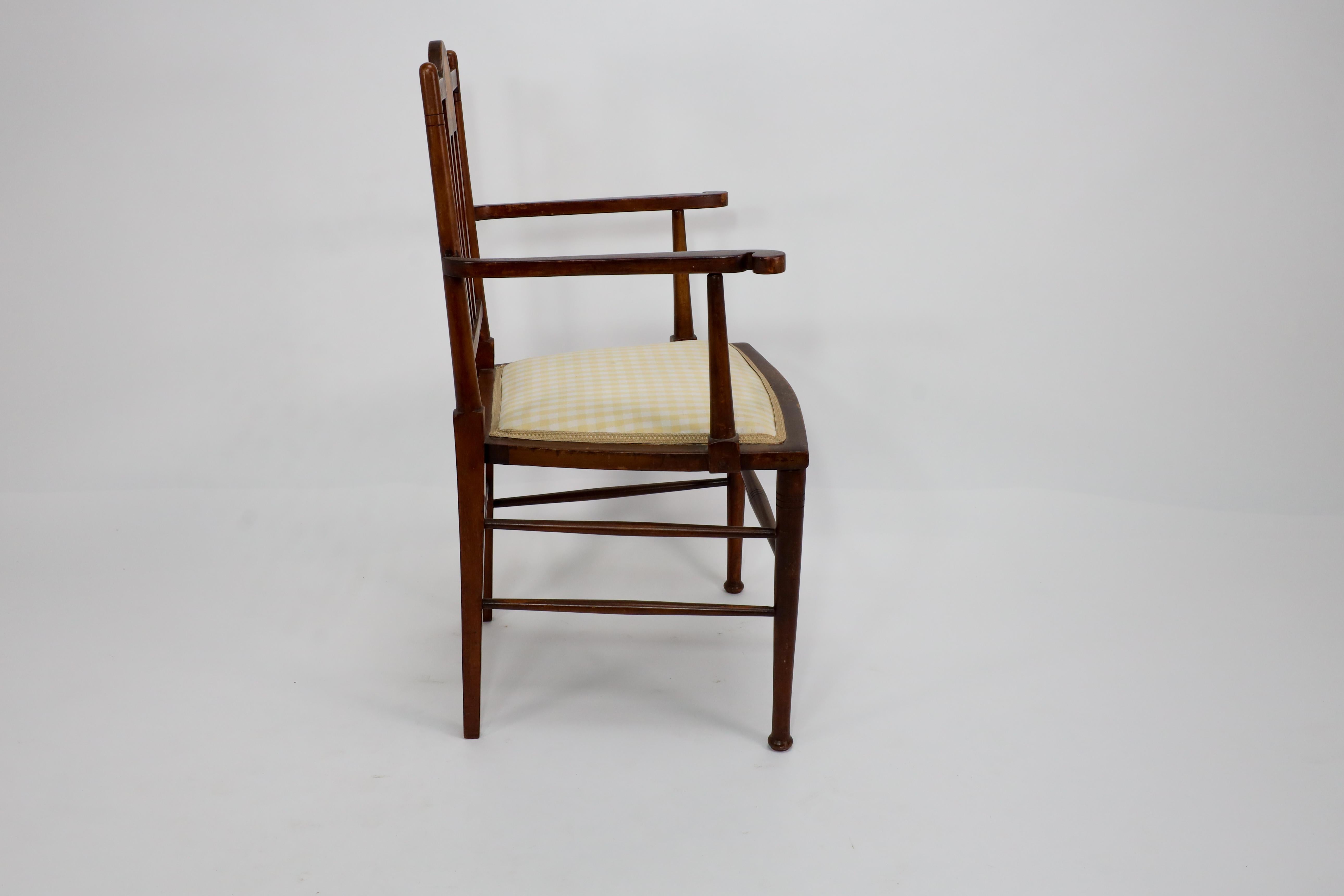 Early 20th Century Liberty and Co in the style of G M Ellwood. An Arts and Crafts Walnut armchair For Sale