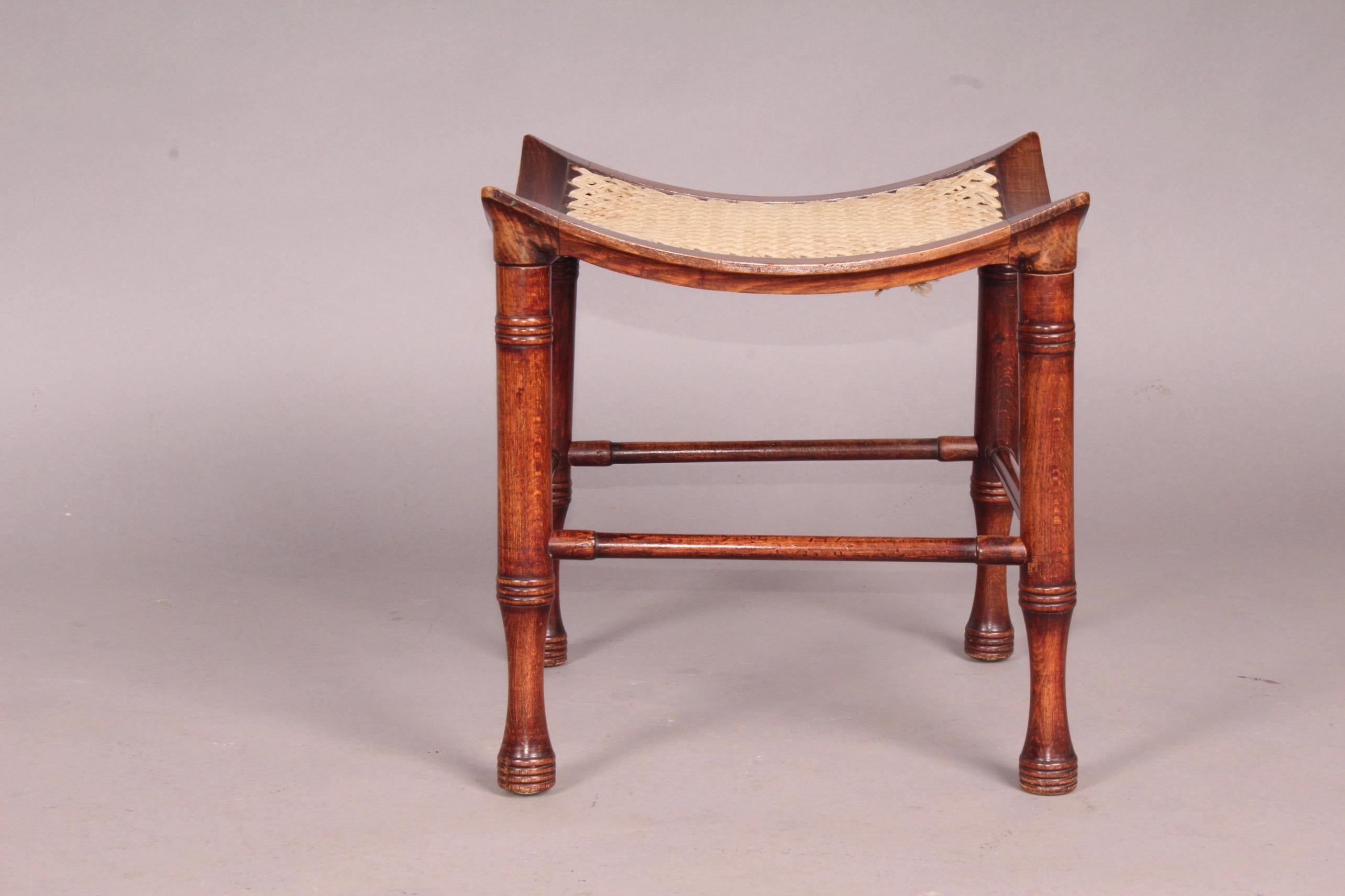 Liberty & Co. stained beech dish shaped Thebes stool with ring turned legs small stain on the fabric.