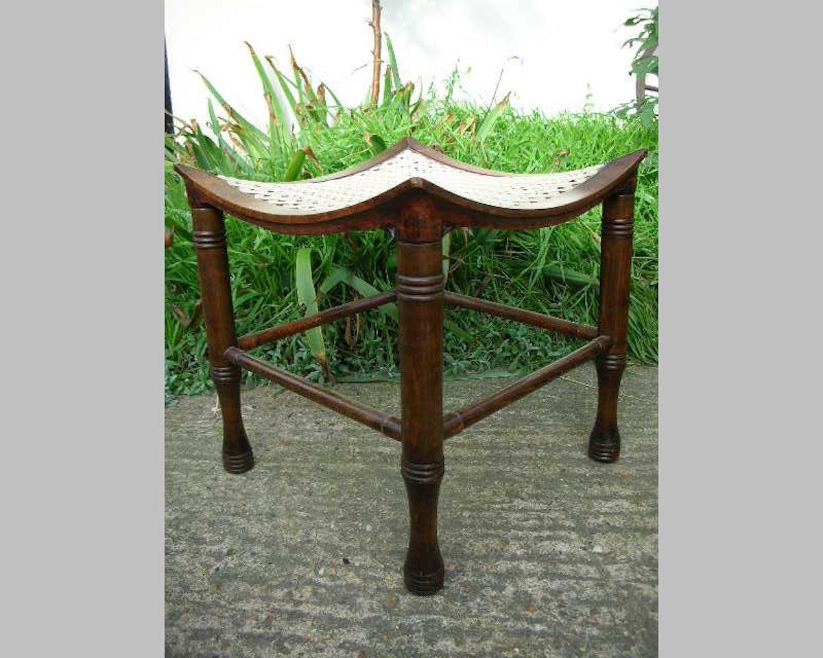 Liberty and Co, a stained beech Thebes stool, with ring turned legs and a re-strung dished seat.