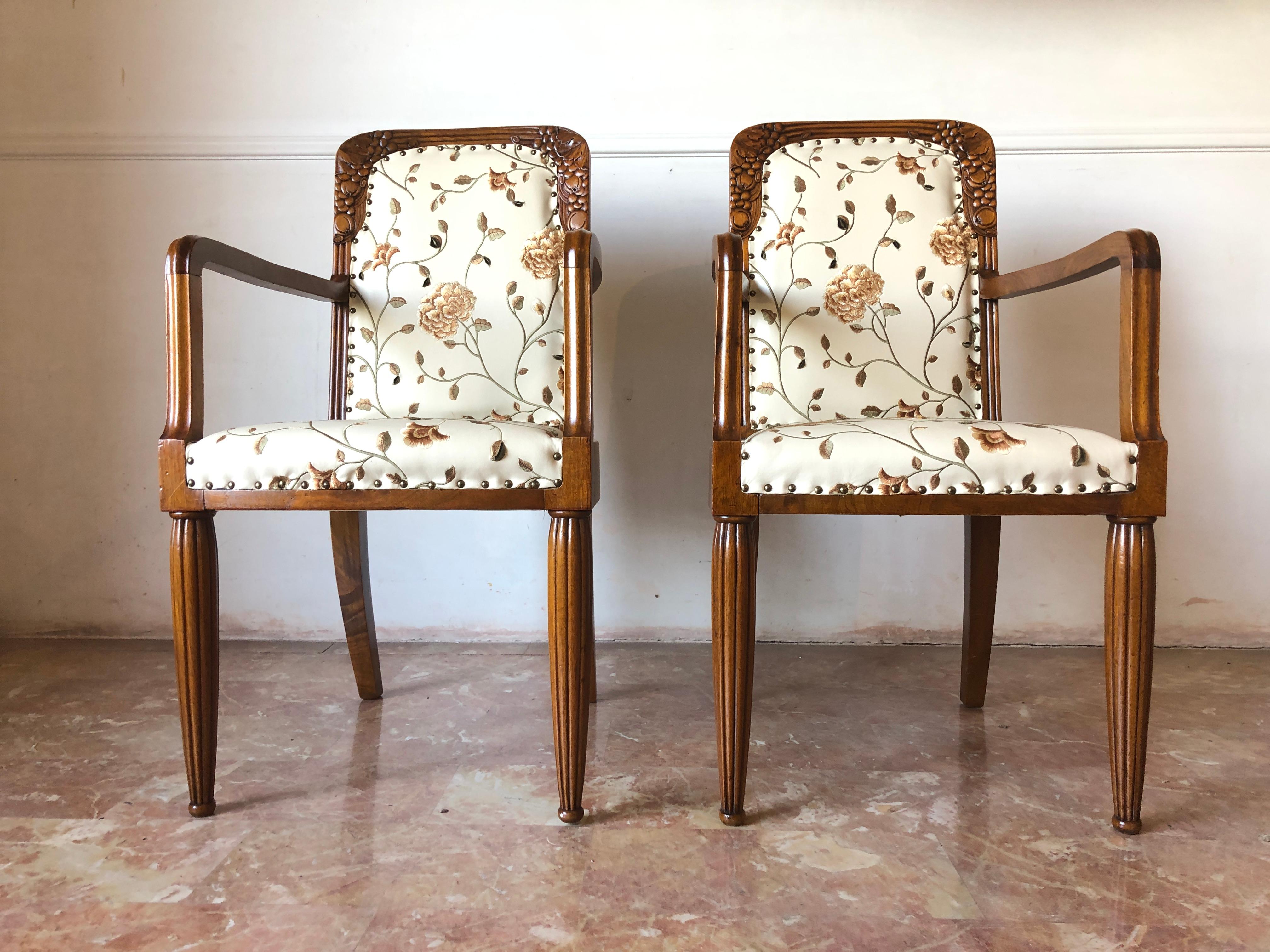 Beautiful French armchairs in walnut with decorative inlays on the backs, grooved legs, new upholstery in faux leather with embossed plant motifs.