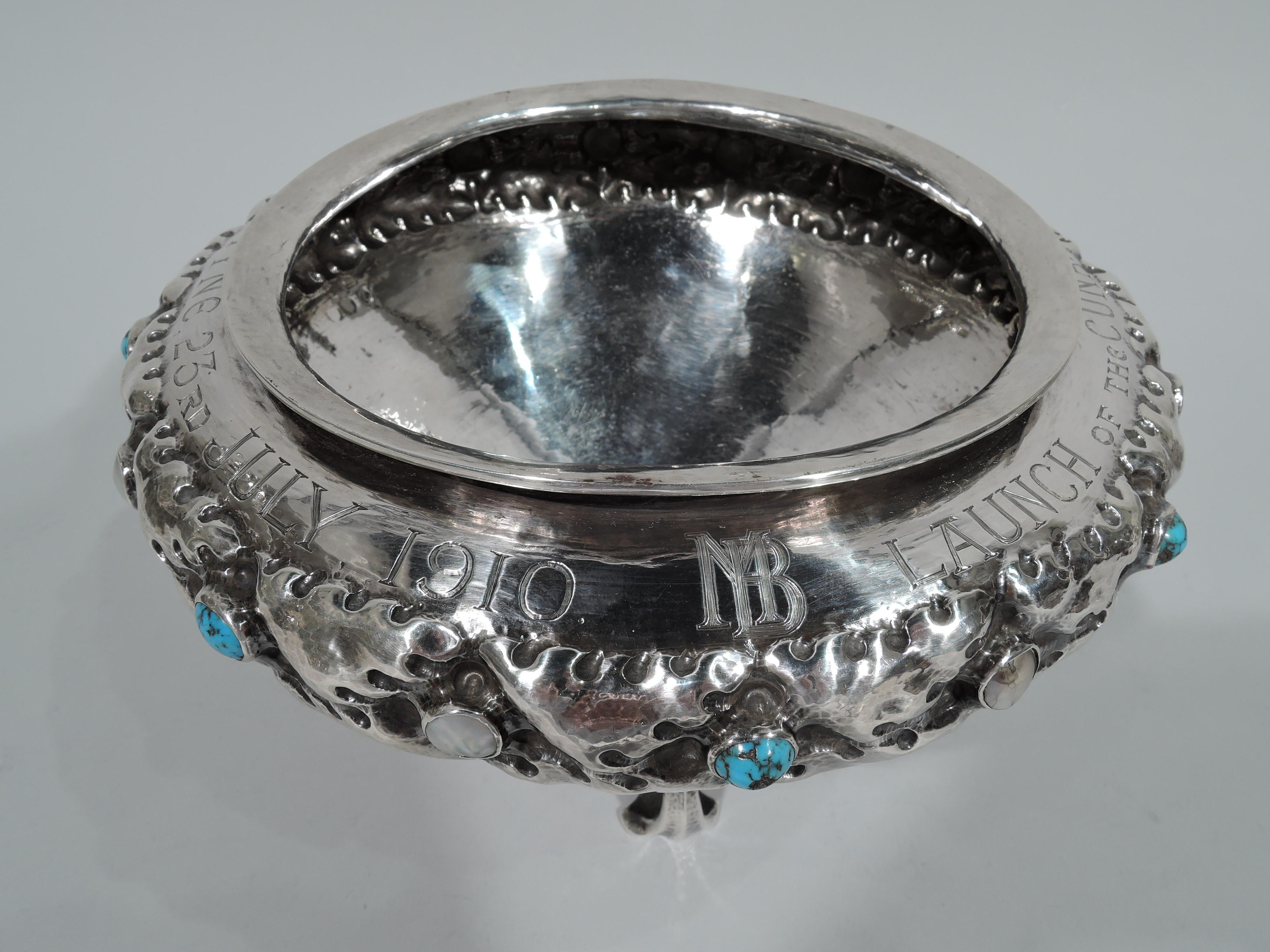 Art Nouveau hand-hammered sterling silver bowl. Made by Liberty & Co., Ltd in Birmingham in 1910. Conical with concentric shimmering. Tooled band with serrated leaves and alternating cabochon turquoise and mother of pearl. Four trefoil-mounted