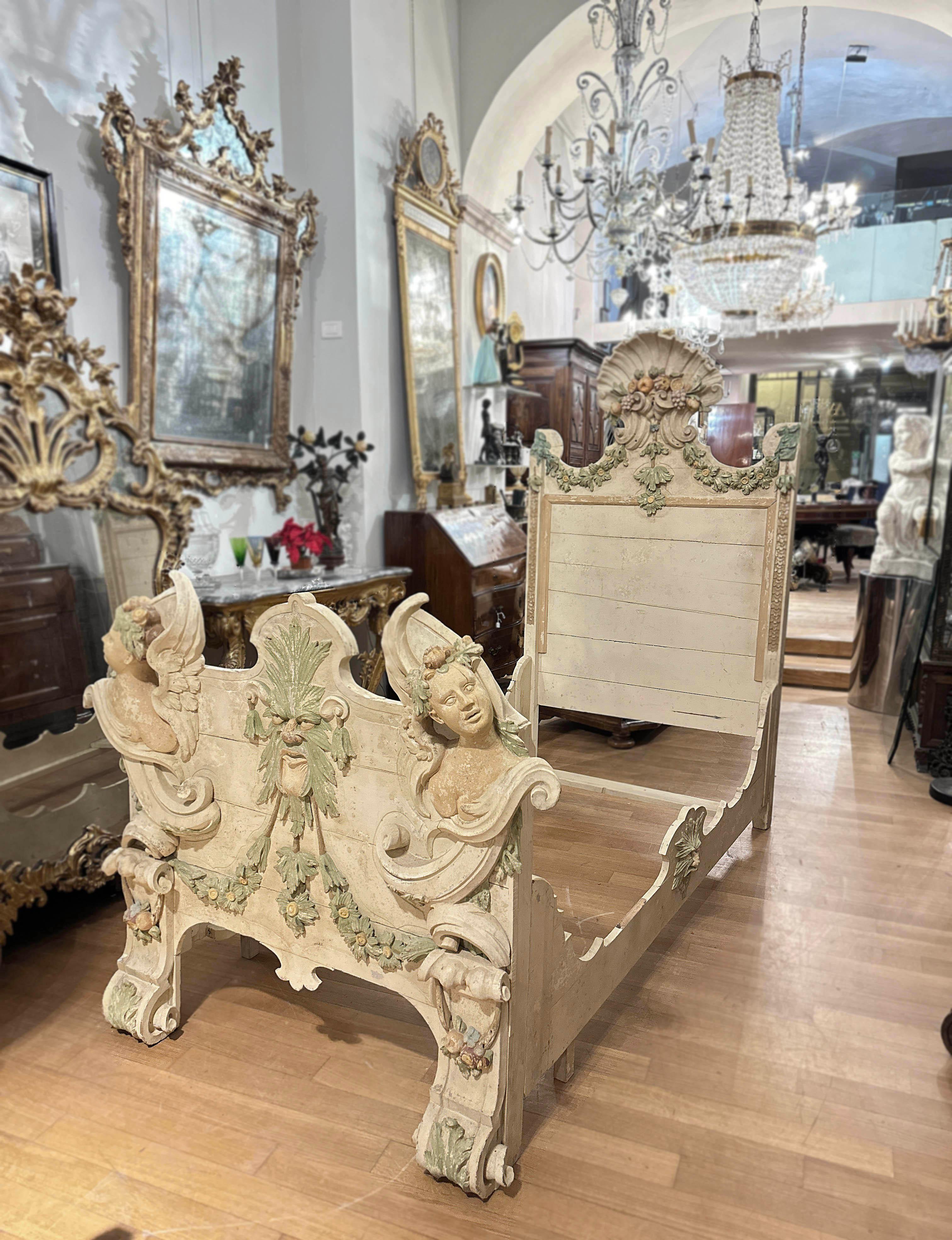 Eclectic single bed in carved wood and lacquered in lean tempera with pastel colours, a typical example of the refined Italian manufacturing of the Liberty period (end of the 19th century). This bed is characterized by particularly detailed