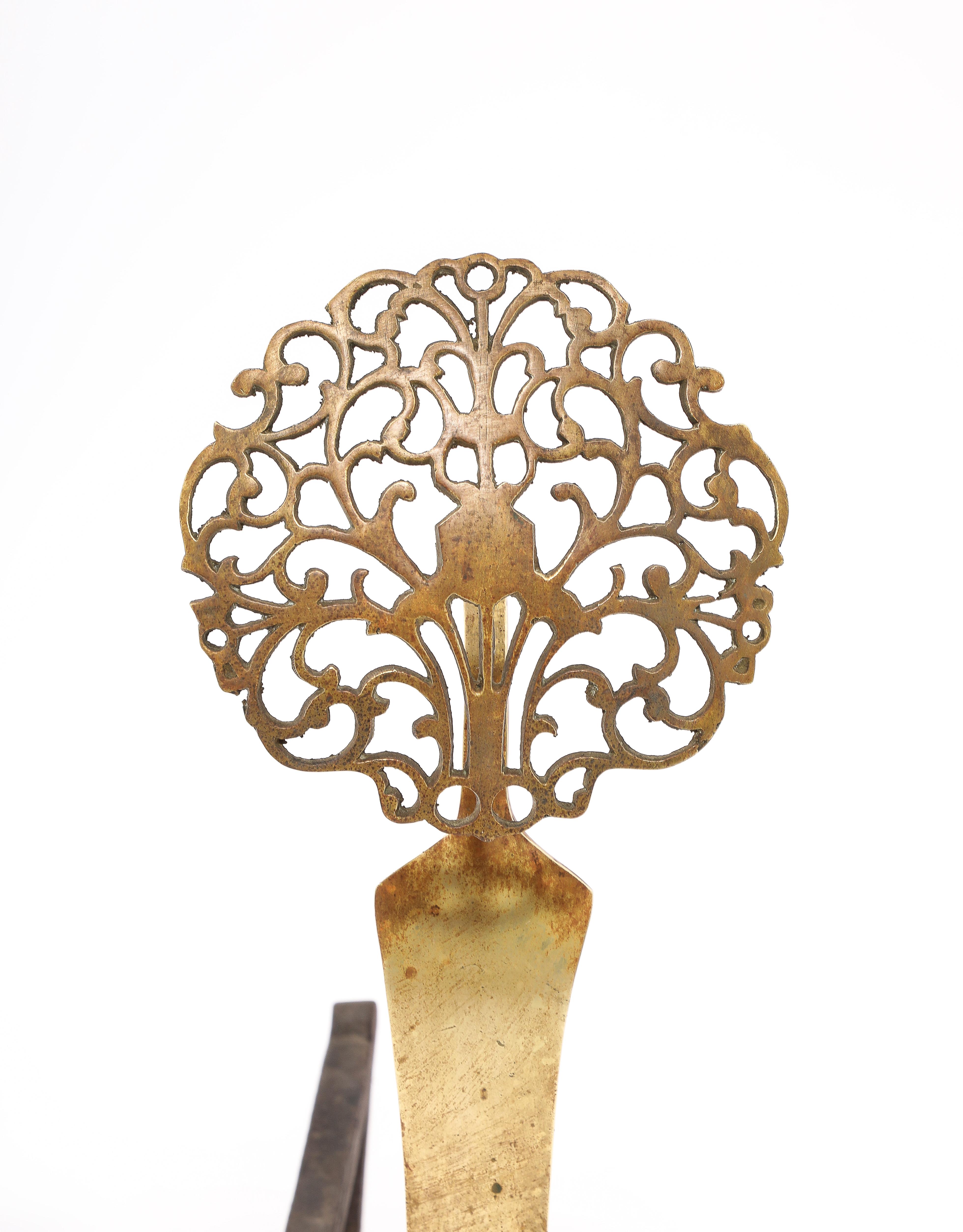 Cast bronze andirons with a delicately carved medallion.
