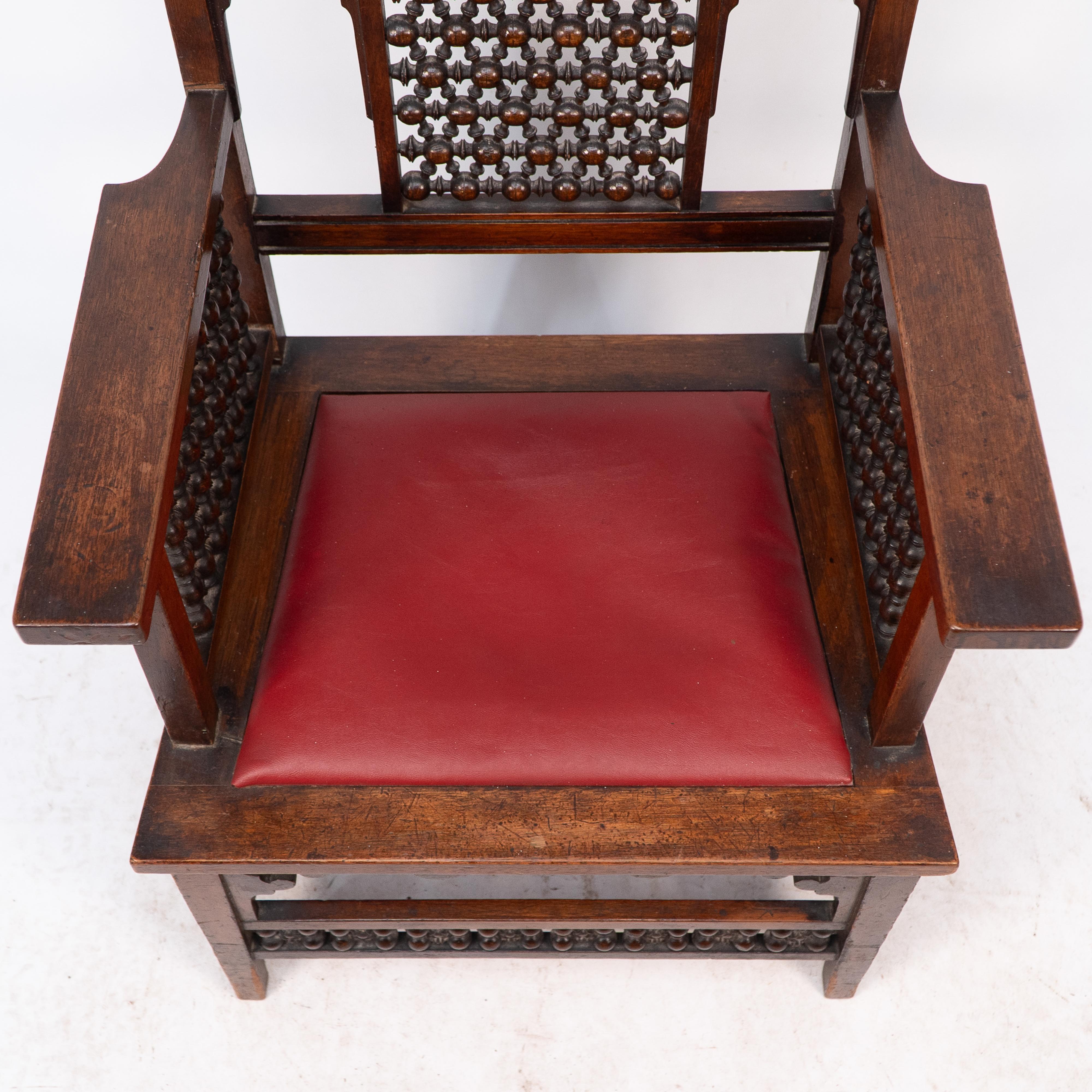 Liberty & Co A Moorish walnut armchair with Mashrabiya turned details throughout For Sale 1
