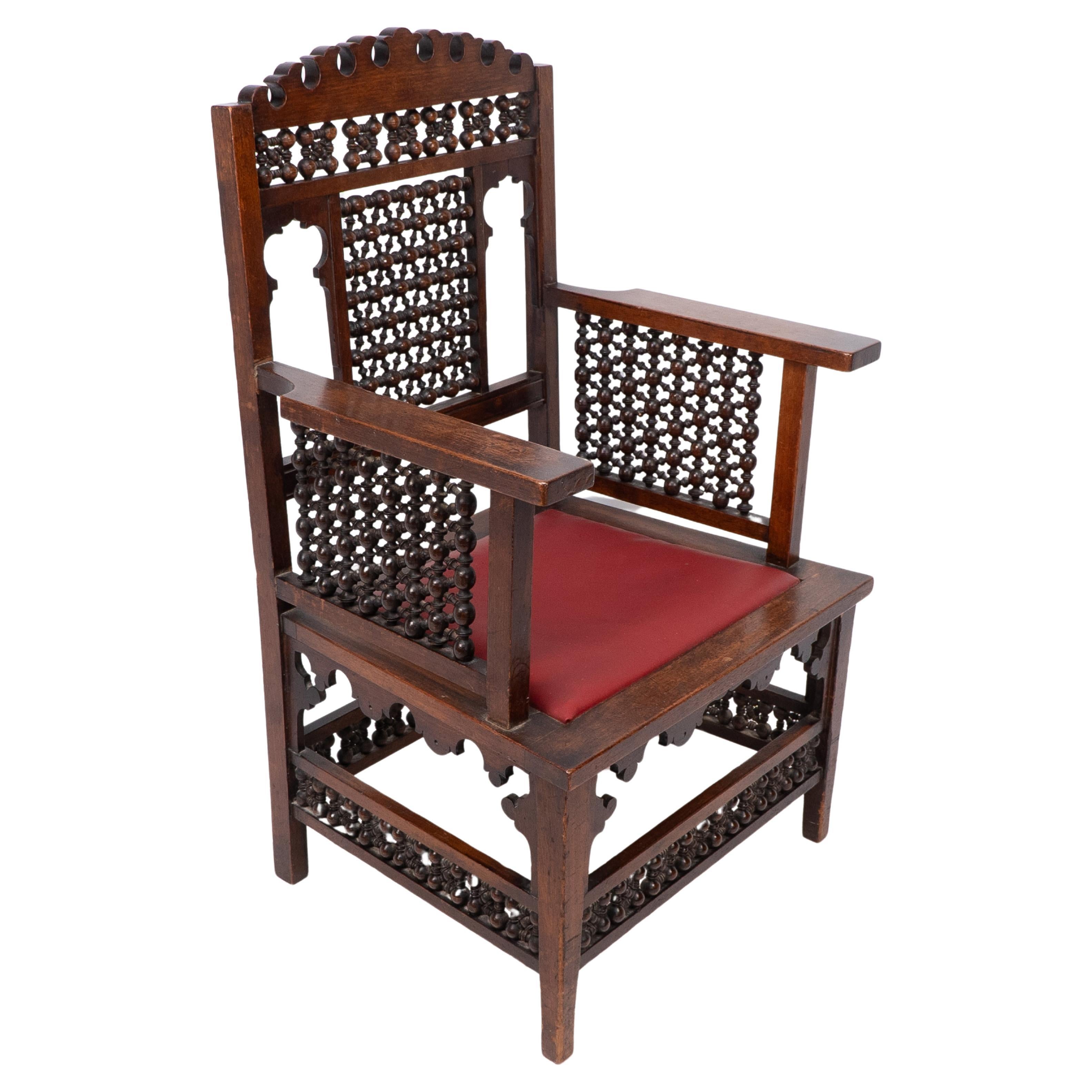 Liberty & Co A Moorish walnut armchair with Mashrabiya turned details throughout For Sale