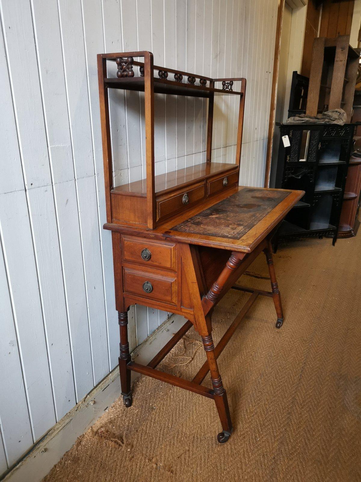 Liberty & Co.
A Moorish Walnut Desk with Mushrabia turnings to the upper shelf, just below to the turned uprights there are dowel holes which I have shown in the images, they are there to hold wooden rods so you can wrap fabric of your choice