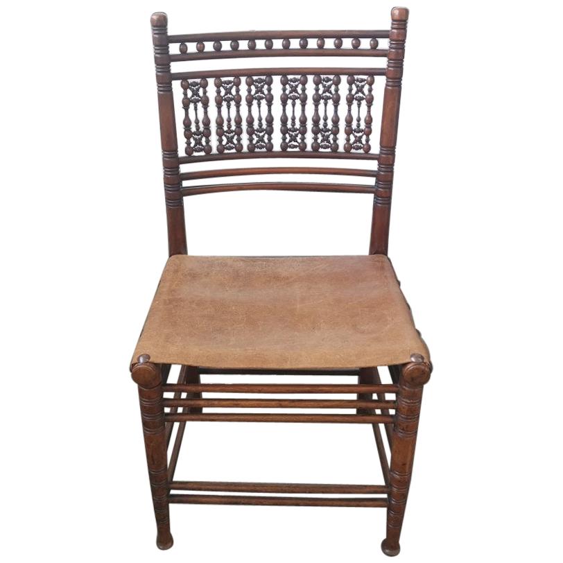 Liberty & Co. A Moorish Walnut Side Chair with Thebes Style Slung Leather Seat