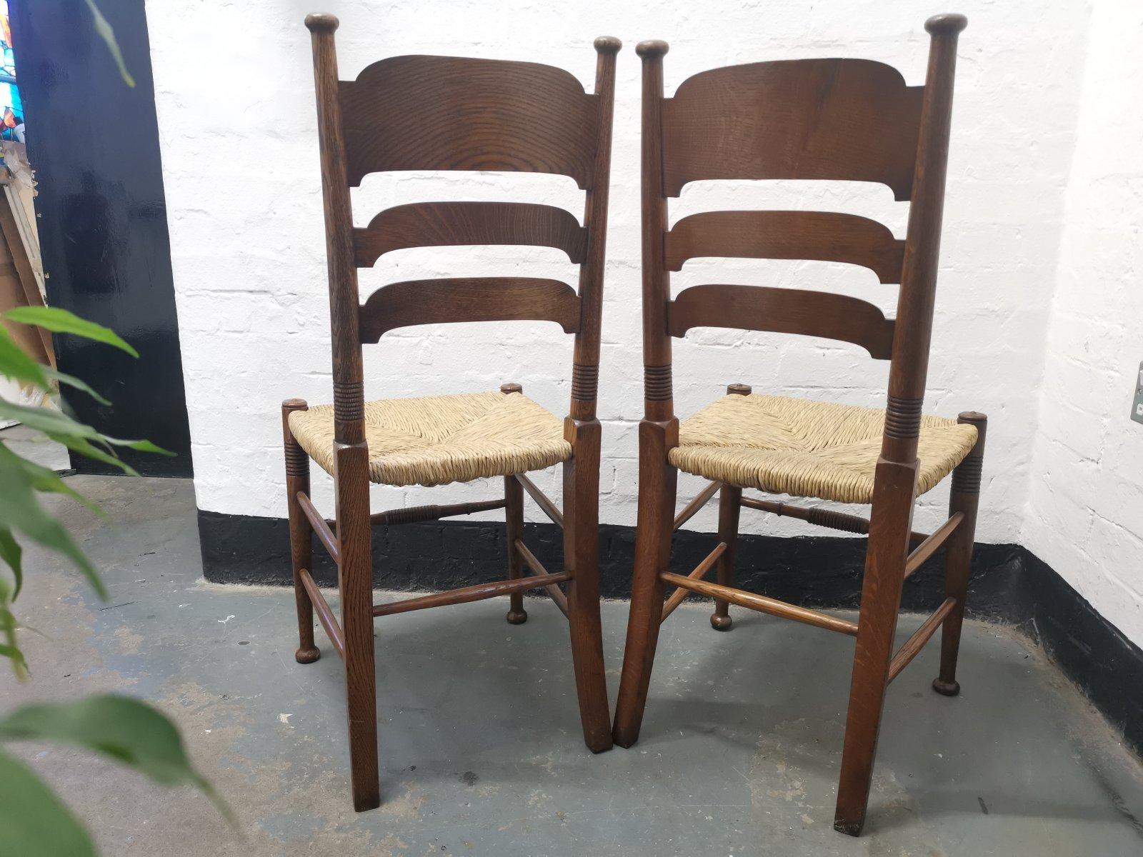 Anglais Liberty & Co. paire de chaises de salle à manger William Birch Arts & Crafts en chêne avec assise en jonc en vente