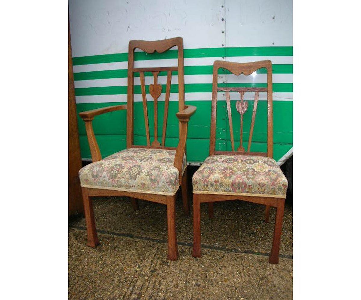 Liberty and Co. A set of five Arts and Crafts oak dining chairs in good original condition with stylized heart details to the backs, shaped turn-out arms, with angular aprons below the seats, stood on square legs with subtle flaring feet.
Armchair