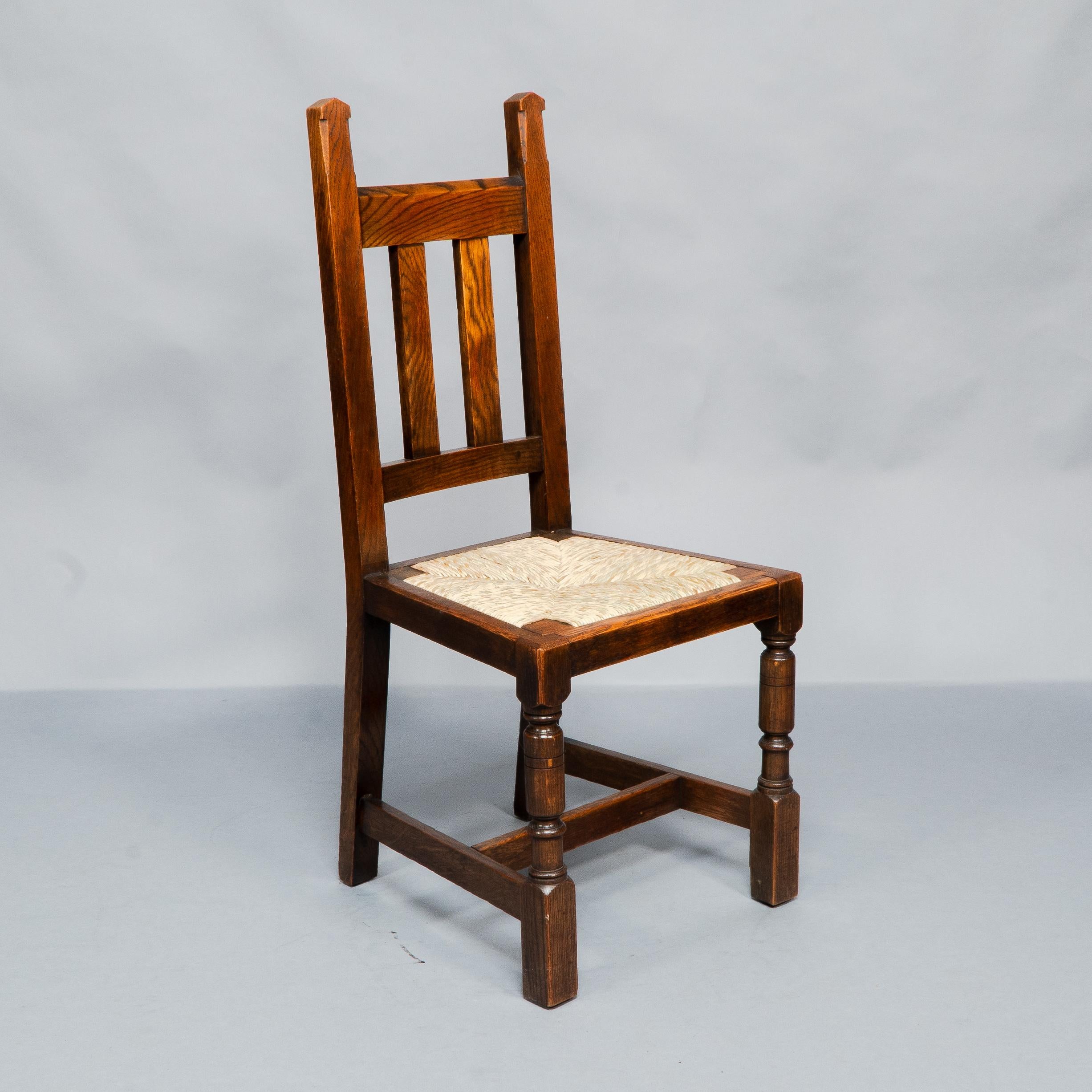 Liberty & Co. A Set of Six Arts & Crafts Oak Arrowhead Rush Seat Dining Chairs. For Sale 4