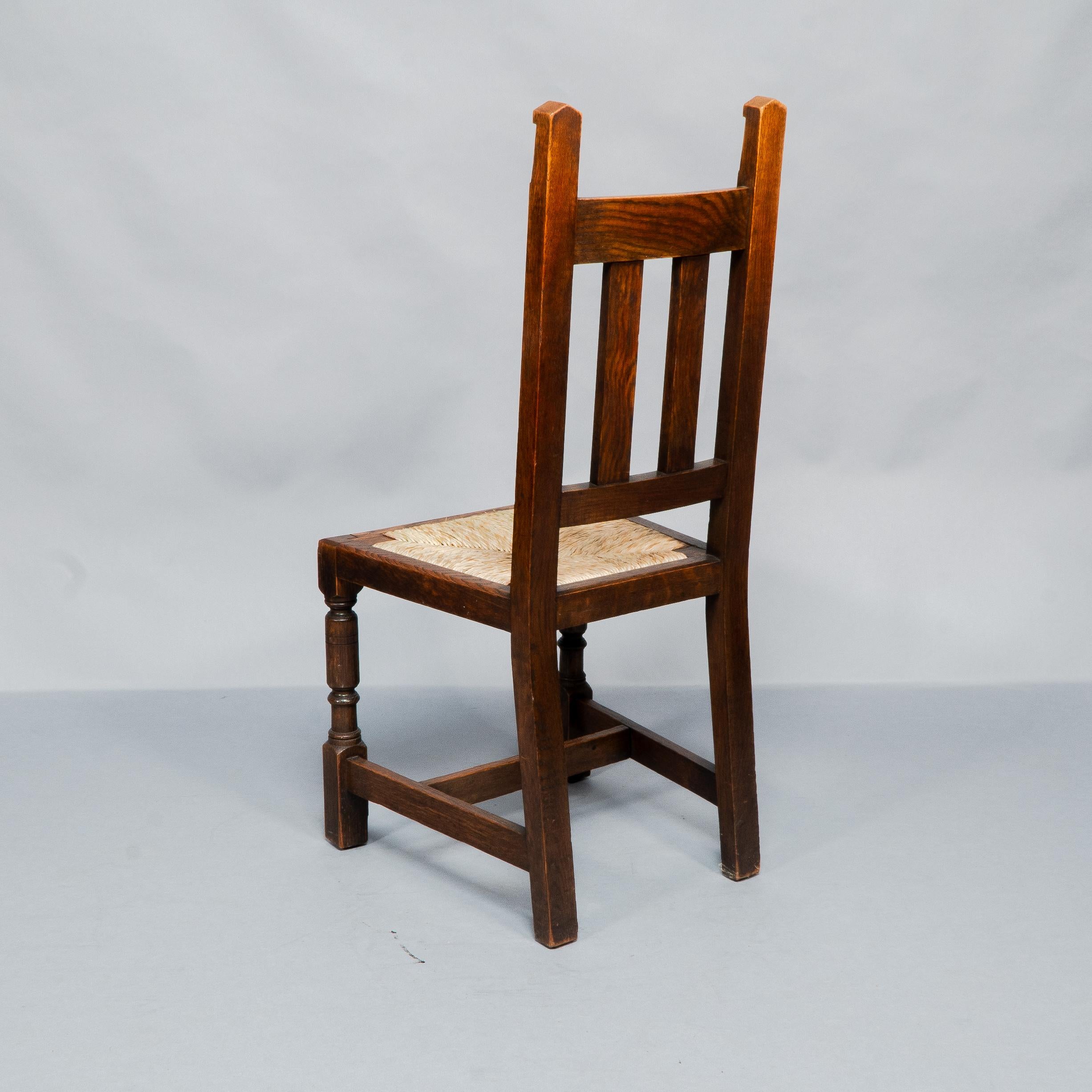 Liberty & Co. A Set of Six Arts & Crafts Oak Arrowhead Rush Seat Dining Chairs. For Sale 1