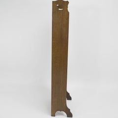 Liberty & Co. A slim Arts and Crafts oak bookcase with stylized floral cut-outs