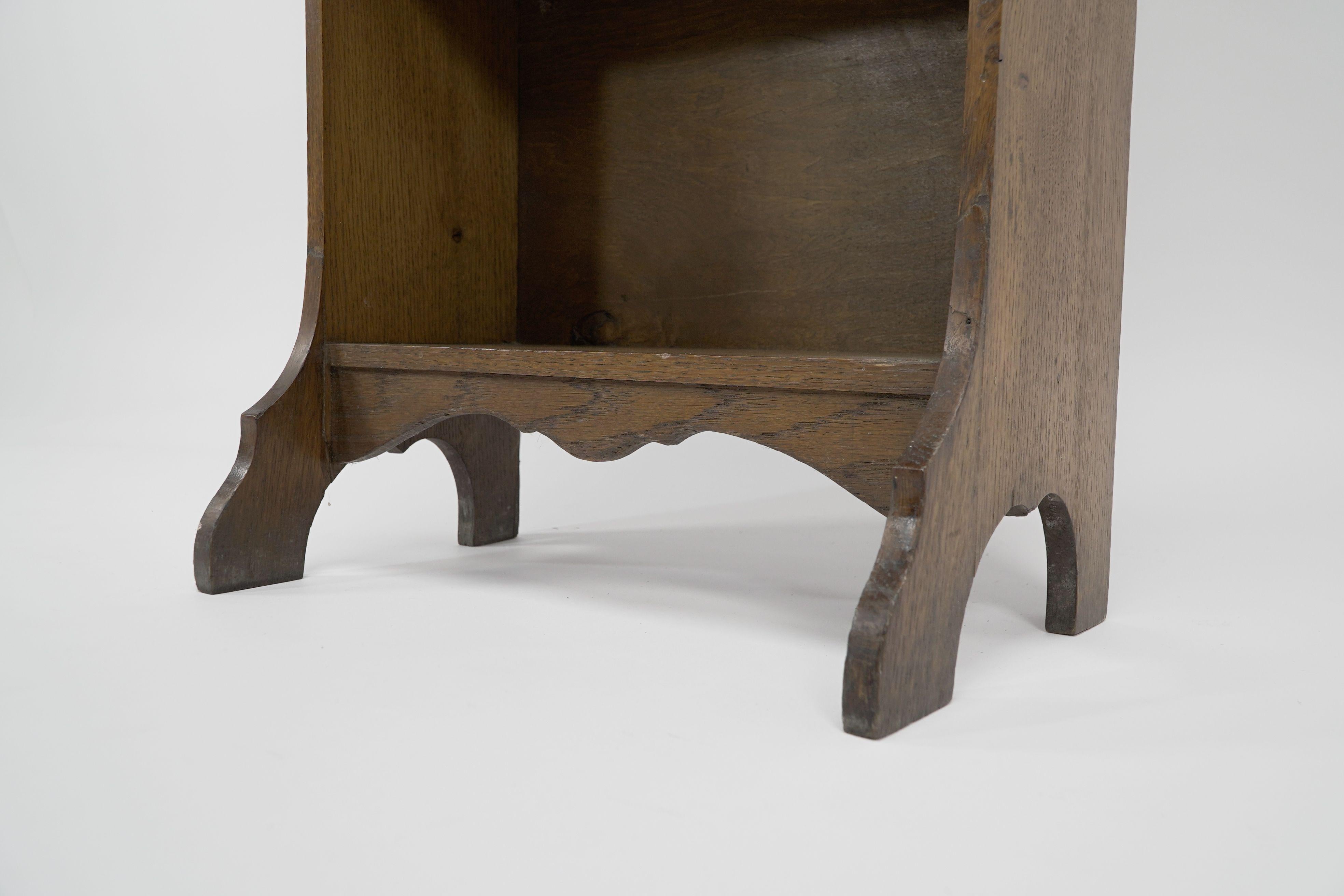 Oak Liberty & Co. A slim Arts and Crafts oak bookcase with stylized floral cut-outs For Sale