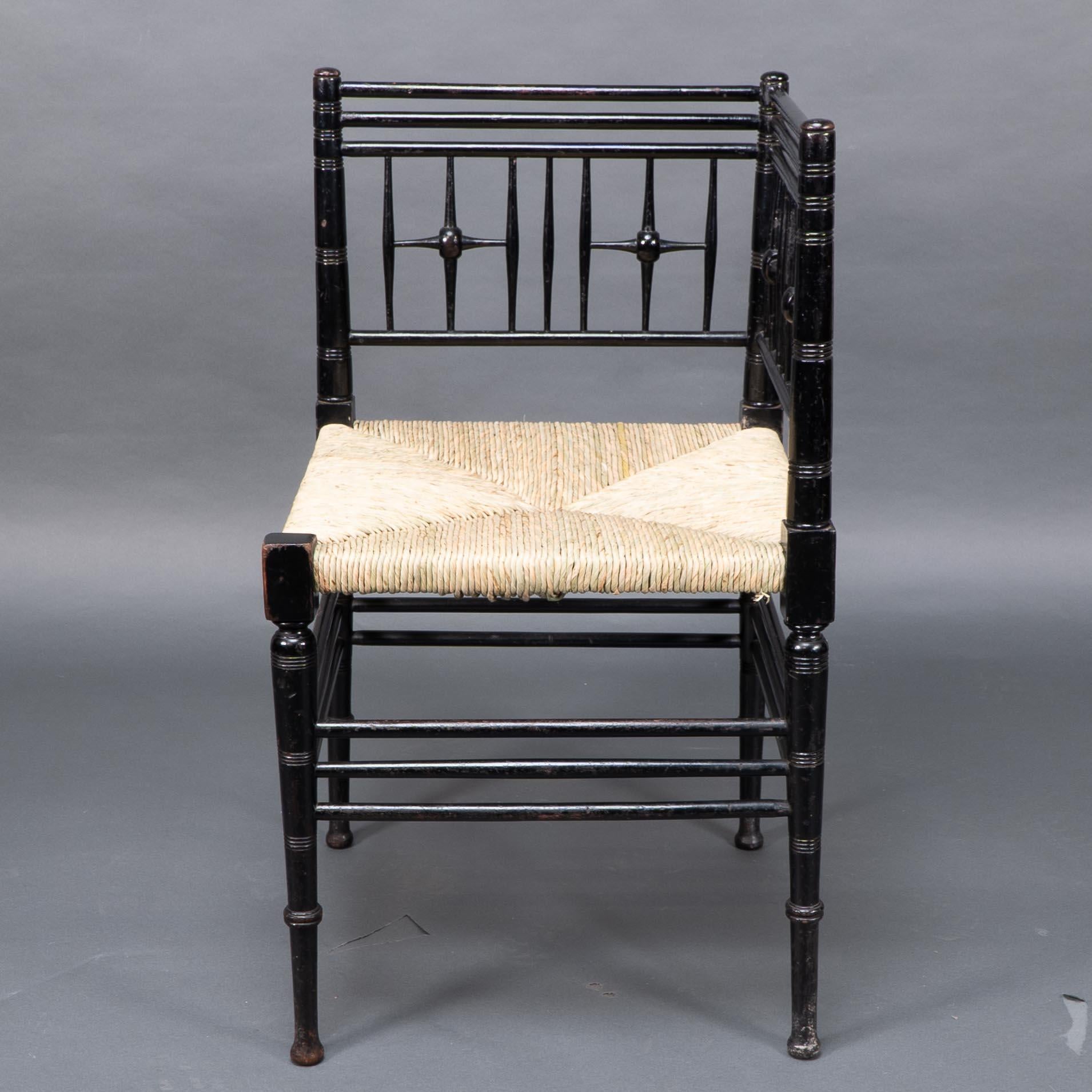 Liberty and Co. An Aesthetic Movement ebonized corner armchair from the Argyll suite designed in 1884. The design is after a Sussex corner chair designed by Ford Madox Brown for Morris and Co. We have recently had it professionally re-rushed.