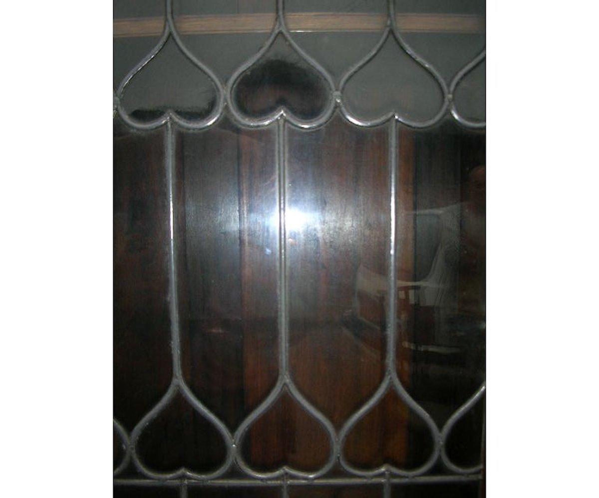 English Liberty & Co. an Arts & Crafts Oak Glazed Bookcase with Stylized Heart Details For Sale