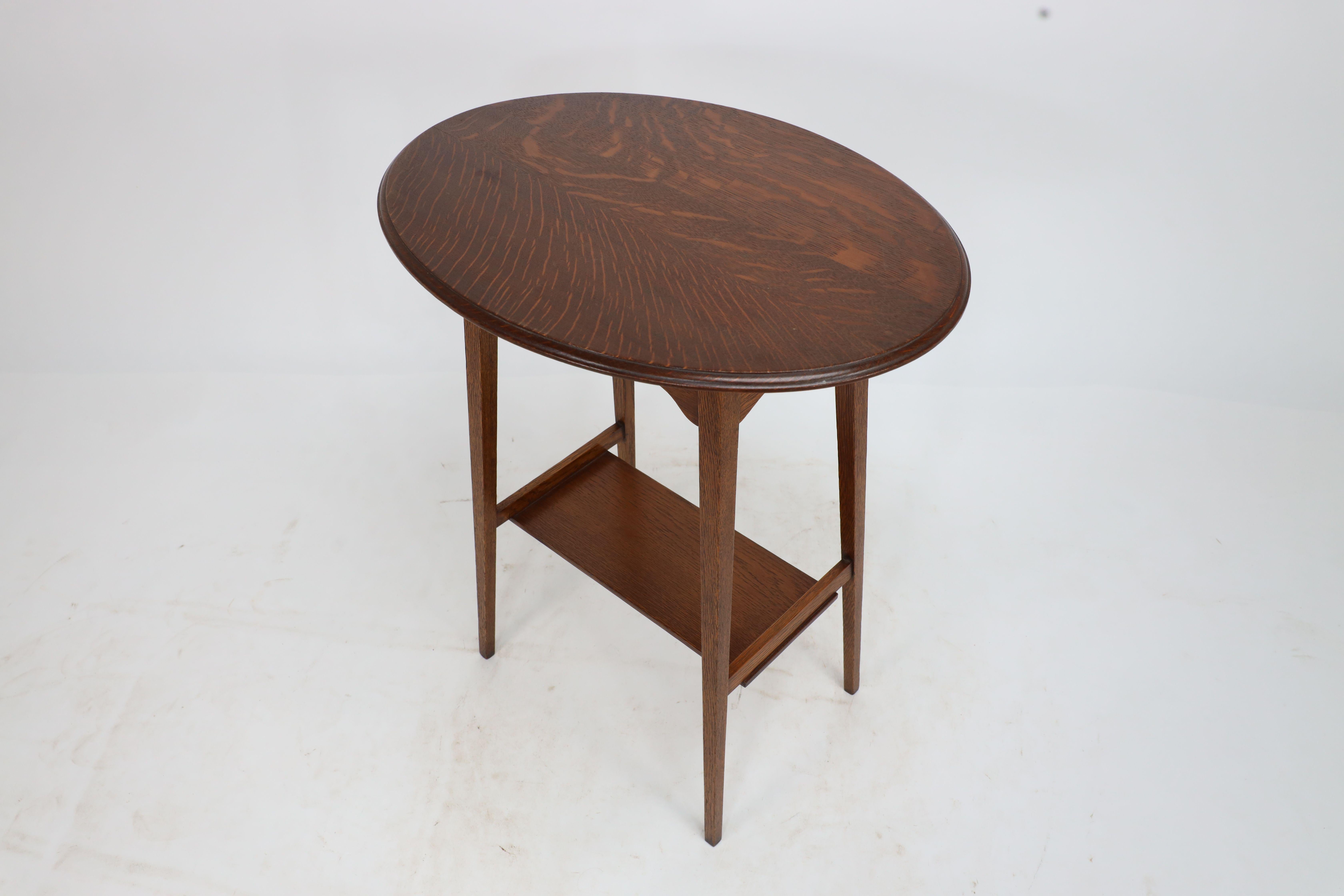 Liberty & Co. An Arts & Crafts oak oval top side table with heart cut-outs 3