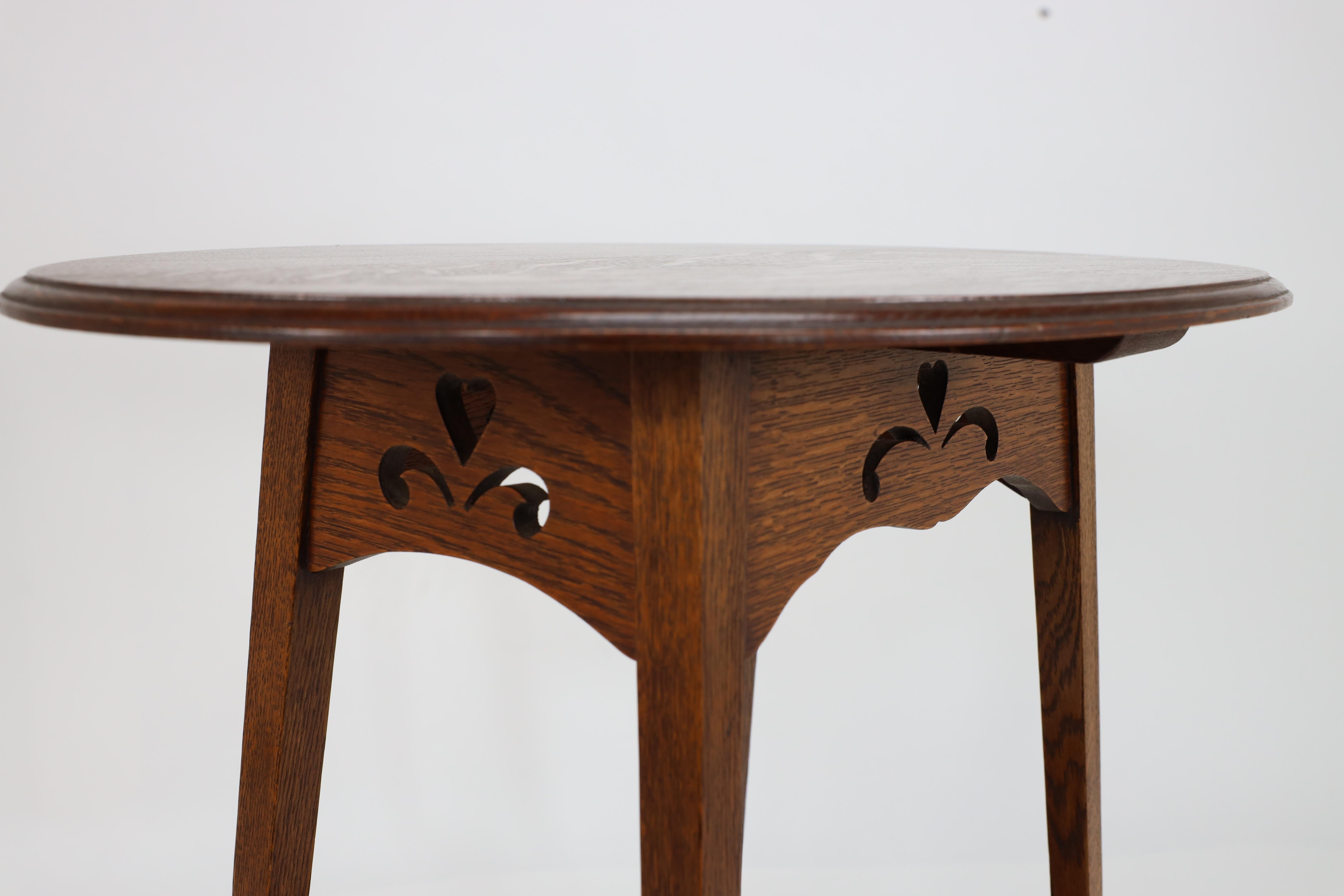 Liberty & Co. An Arts & Crafts oak oval top side table with heart cut-outs 10